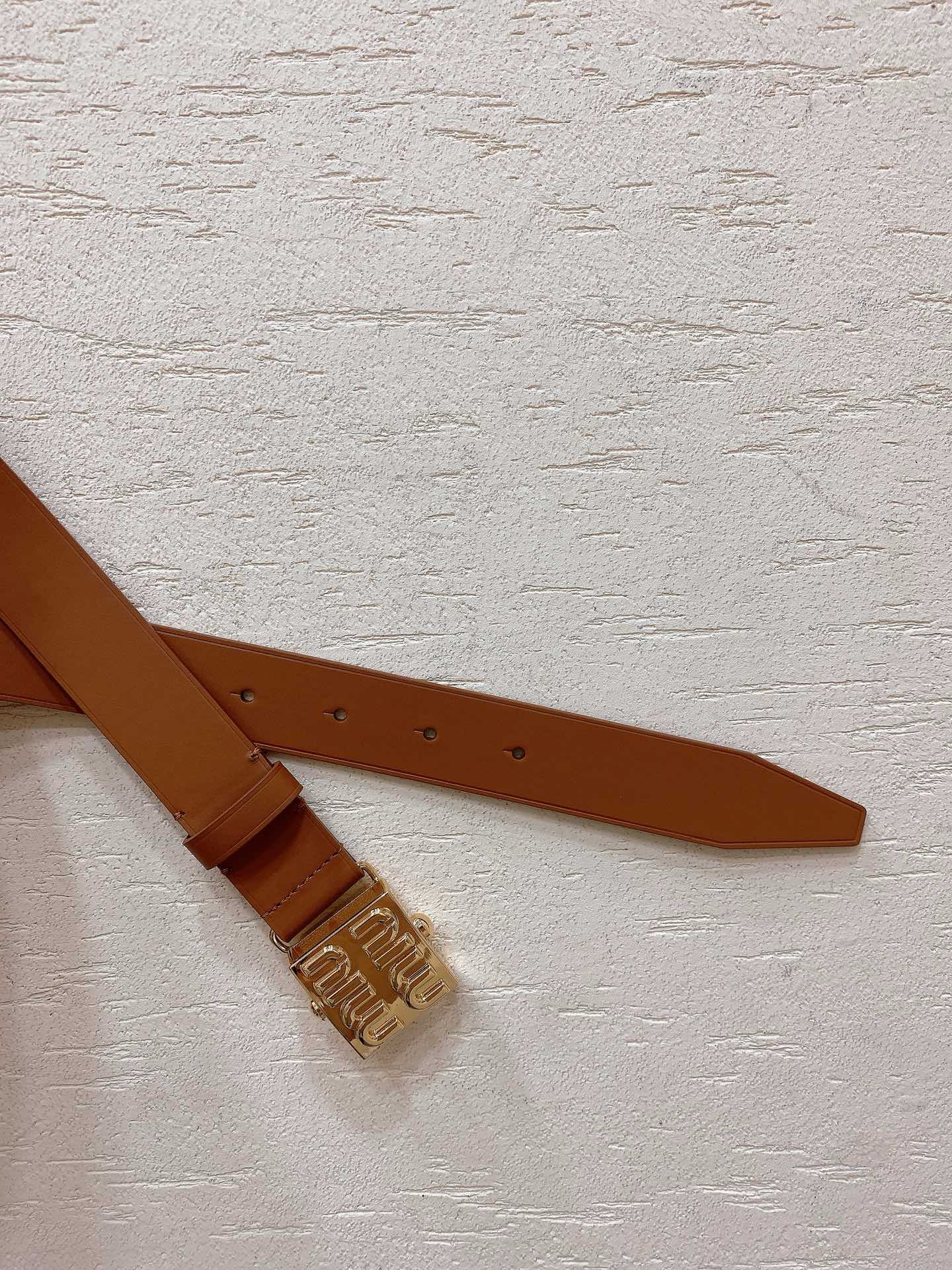 Brown leather belt with gold metal buckle engraved with Miu Miu