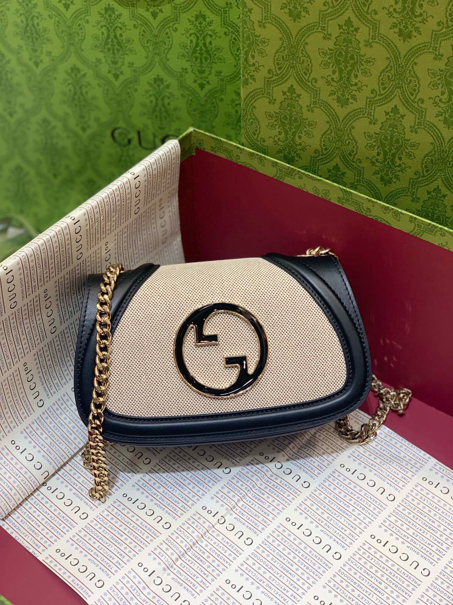 Gucci Blondie Canvas Shoulder Bag with black leather trim, gold interlocking G logo, and chain strap in a luxury box.