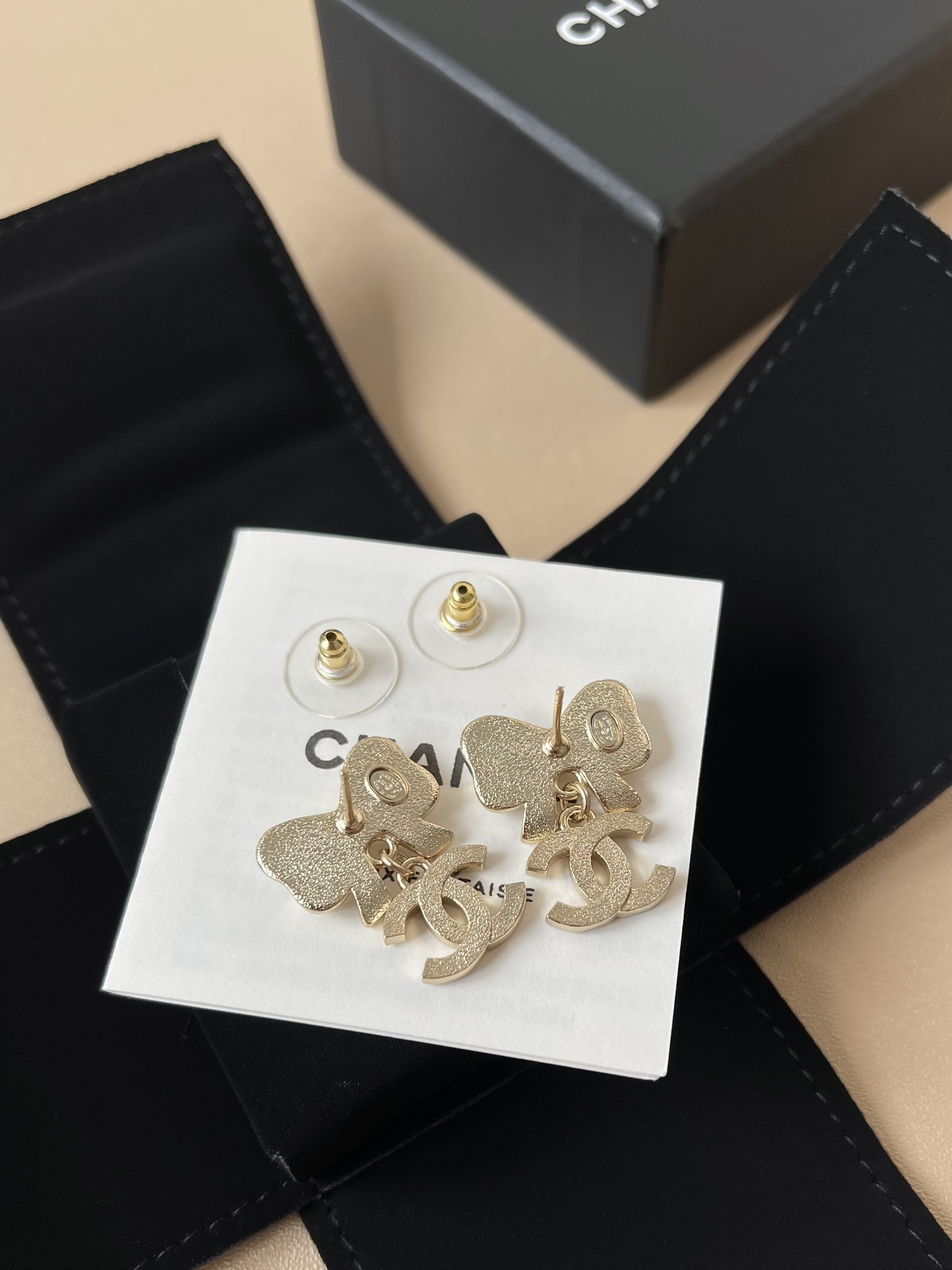 Elegant White Bow & Crystal Logo Dangle Earrings - Gold Tone