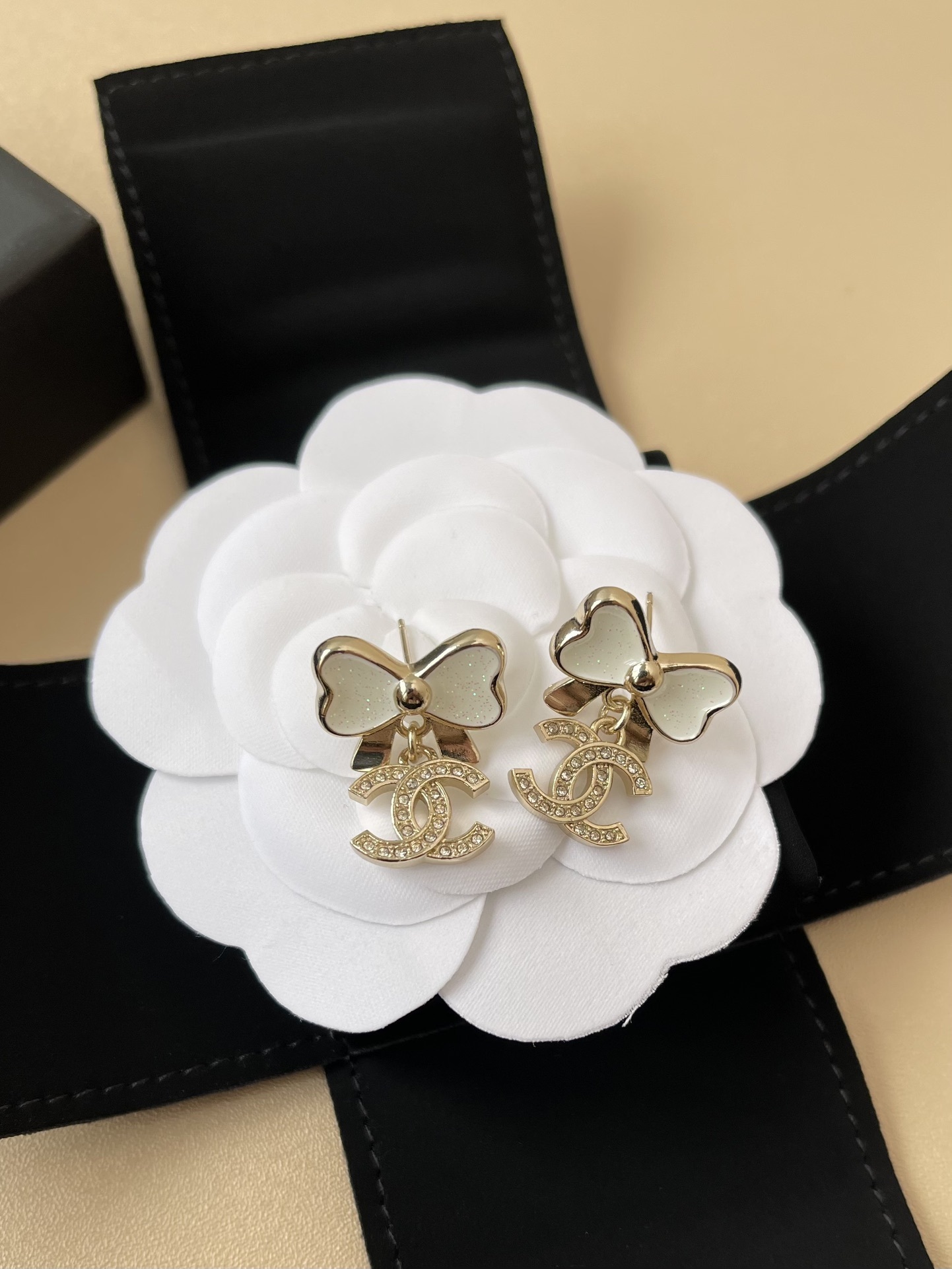 Elegant White Bow & Crystal Logo Dangle Earrings - Gold Tone