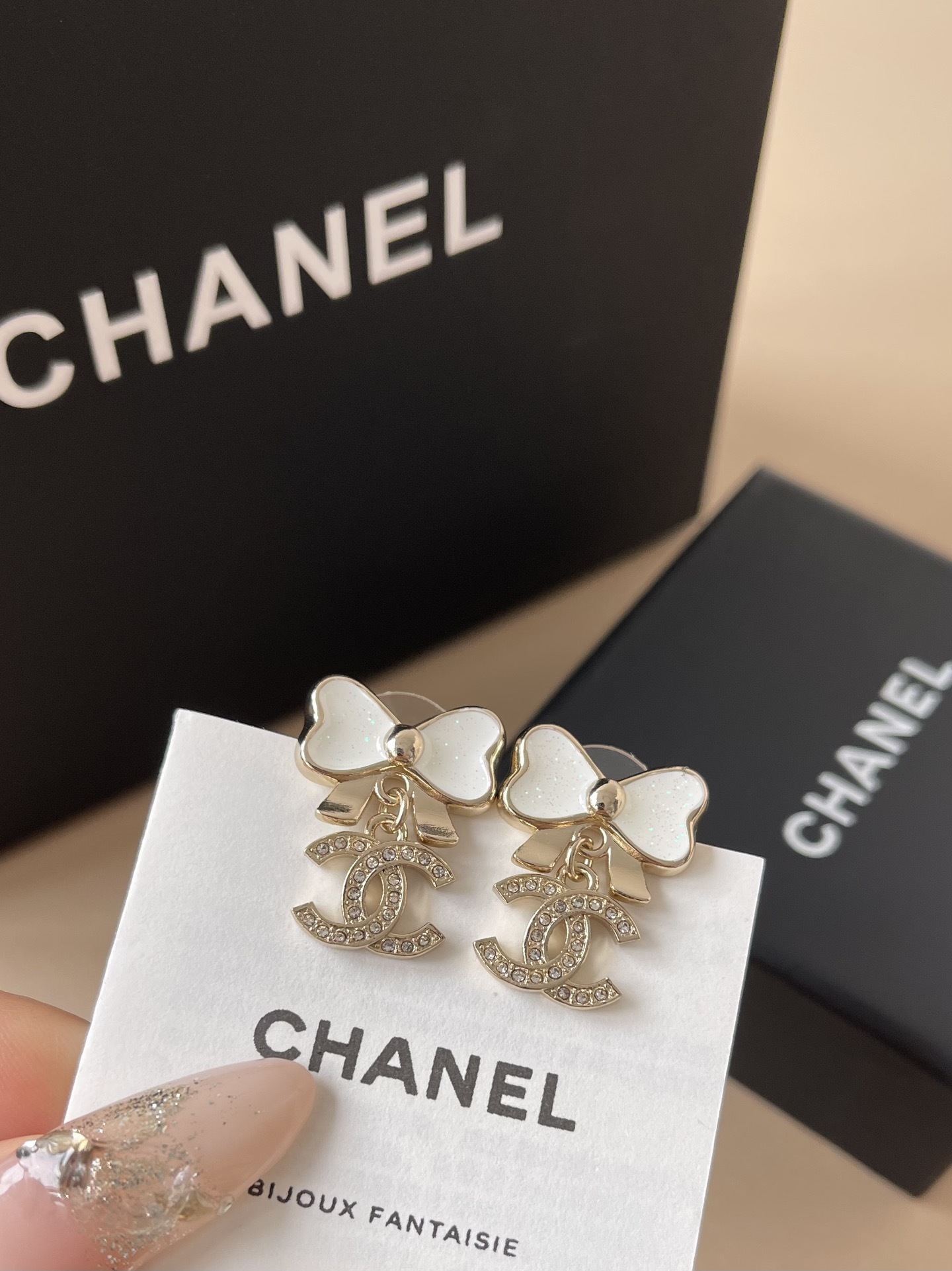 Elegant White Bow & Crystal Logo Dangle Earrings - Gold Tone