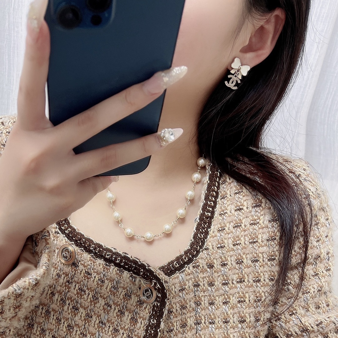 Elegant White Bow & Crystal Logo Dangle Earrings - Gold Tone