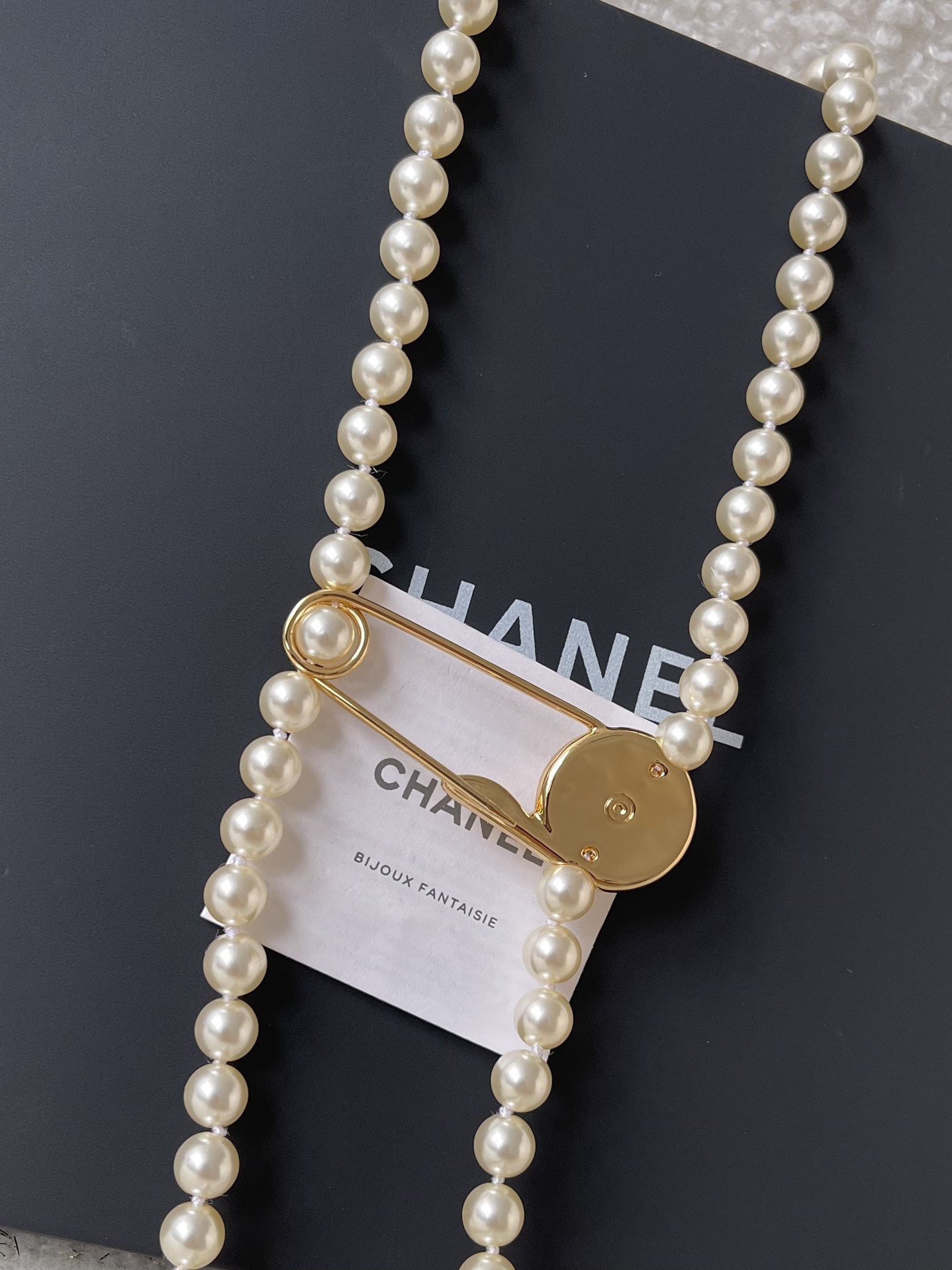 Elegant Long Pearl Necklace with Gold Safety Pin Logo Pendant