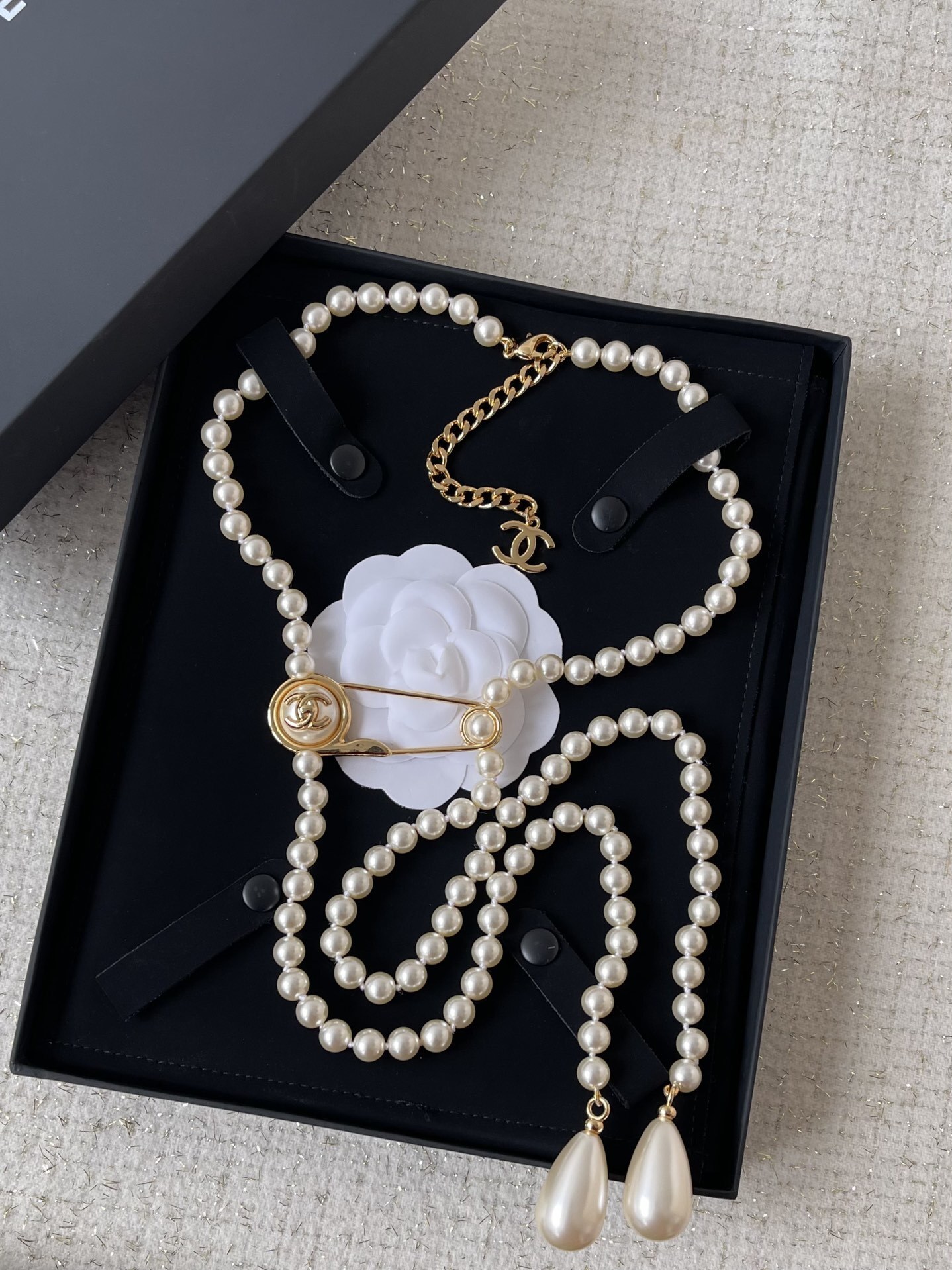 Elegant Long Pearl Necklace with Gold Safety Pin Logo Pendant