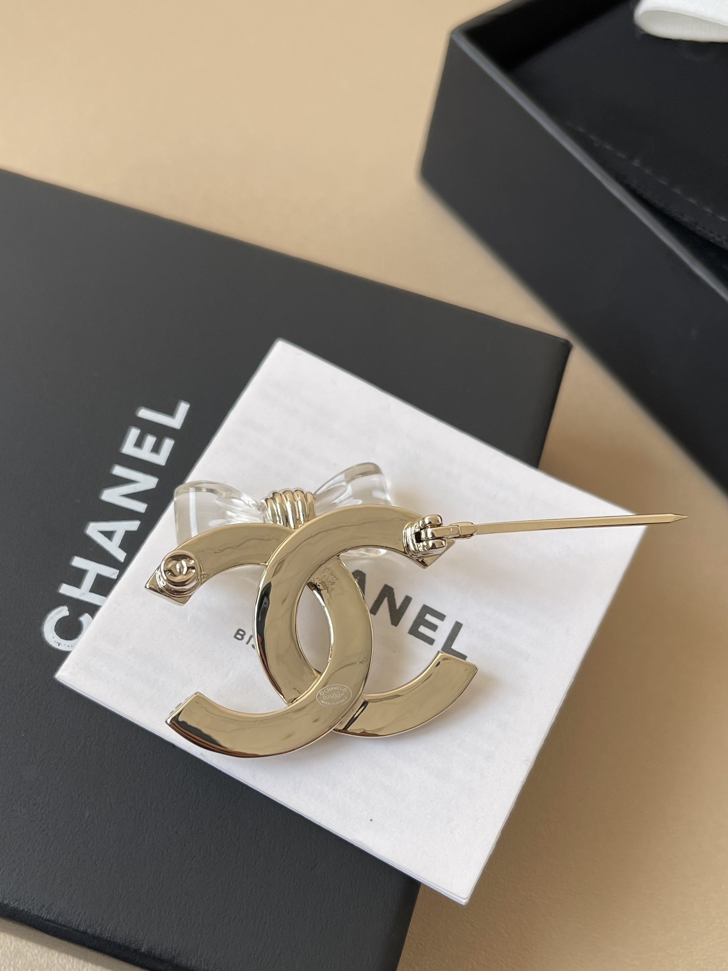 Elegant Gold-Tone CC Interlocking Brooch with Transparent Bow