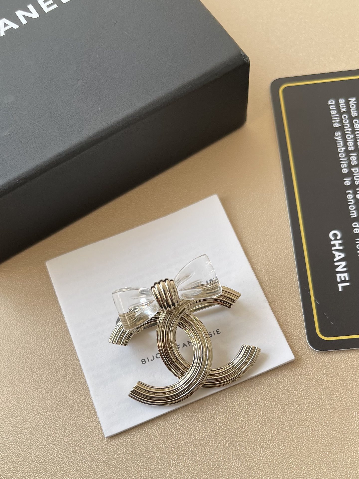 Elegant Gold-Tone CC Interlocking Brooch with Transparent Bow