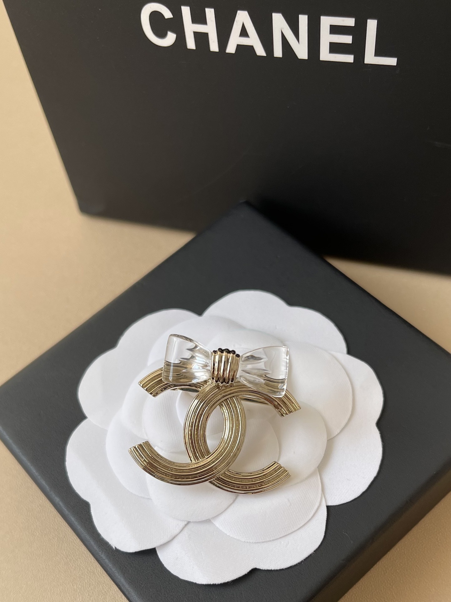 Elegant Gold-Tone CC Interlocking Brooch with Transparent Bow
