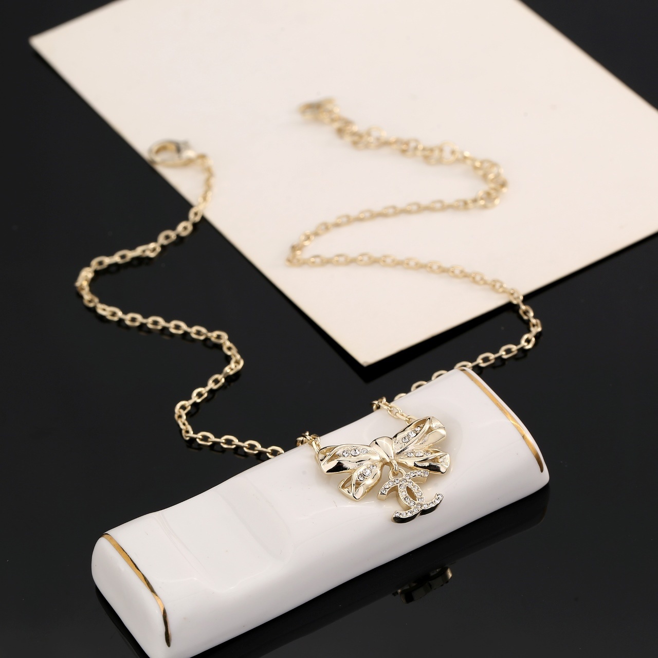 Elegant Gold Ribbon Bow Necklace with Sparkling CC Pendant