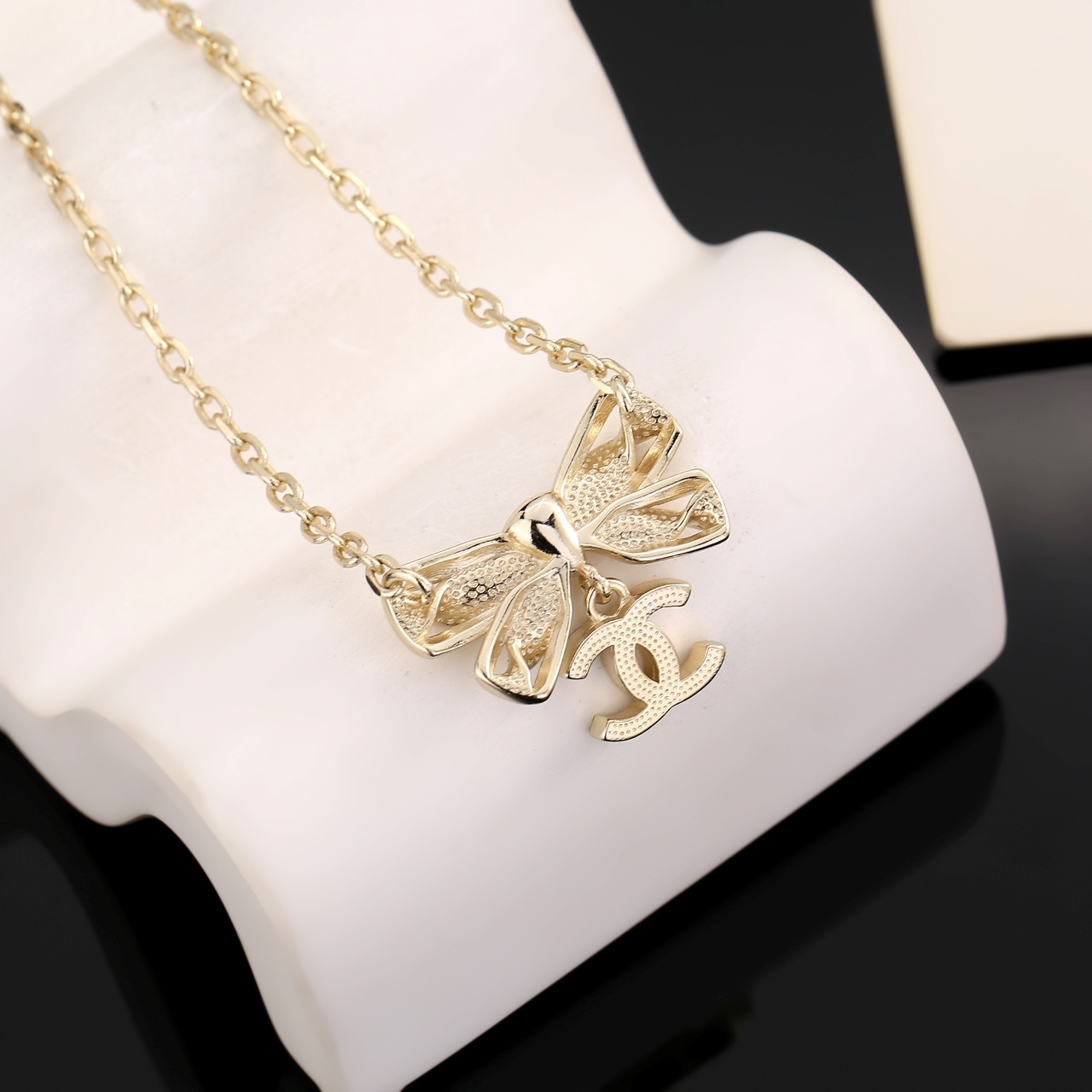 Elegant Gold Ribbon Bow Necklace with Sparkling CC Pendant