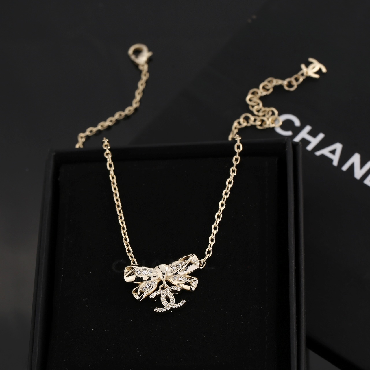 Elegant Gold Ribbon Bow Necklace with Sparkling CC Pendant