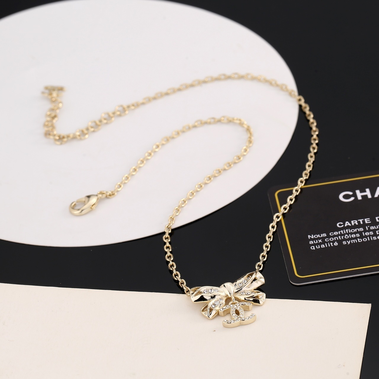 Elegant Gold Ribbon Bow Necklace with Sparkling CC Pendant