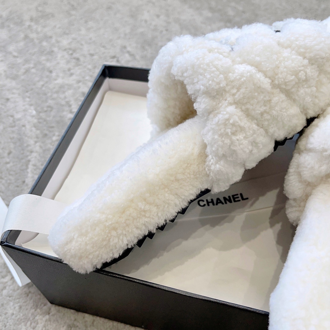 A pair of premium white fuzzy shearling slides with a black interlaced logo displayed on a designer shoebox. - Hình 8
