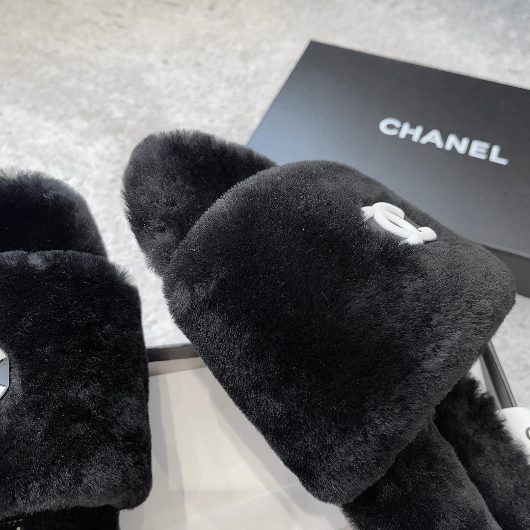 A pair of black fluffy faux fur slides with a white interlocking CC logo placed on a black designer shoe box. - Hình 7
