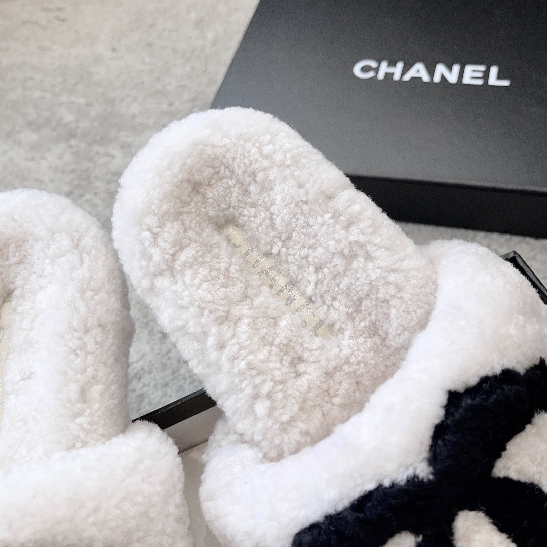 Pair of white plush shearling slides with black interlocking CC logo sitting on a designer box - Hình 9