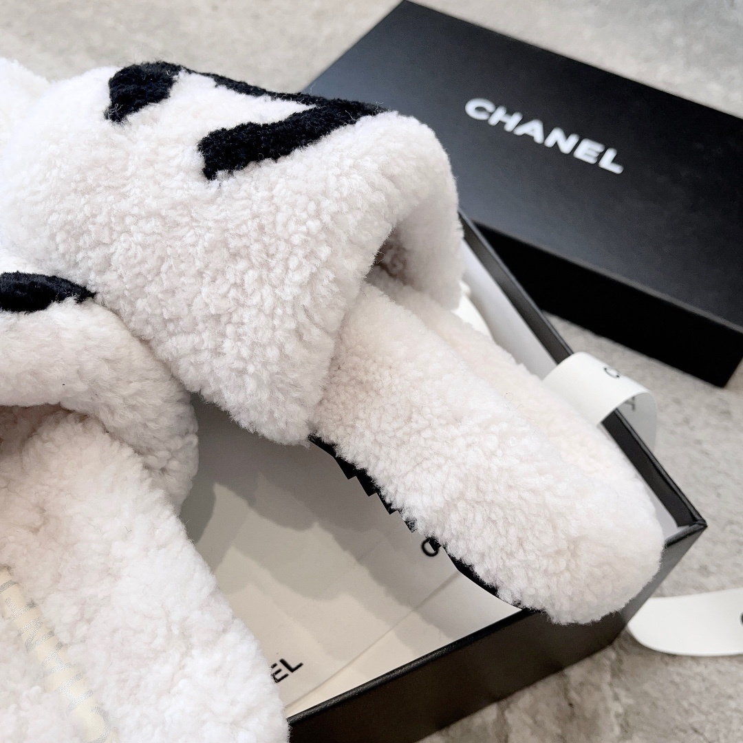 Pair of white plush shearling slides with black interlocking CC logo sitting on a designer box - Hình 8