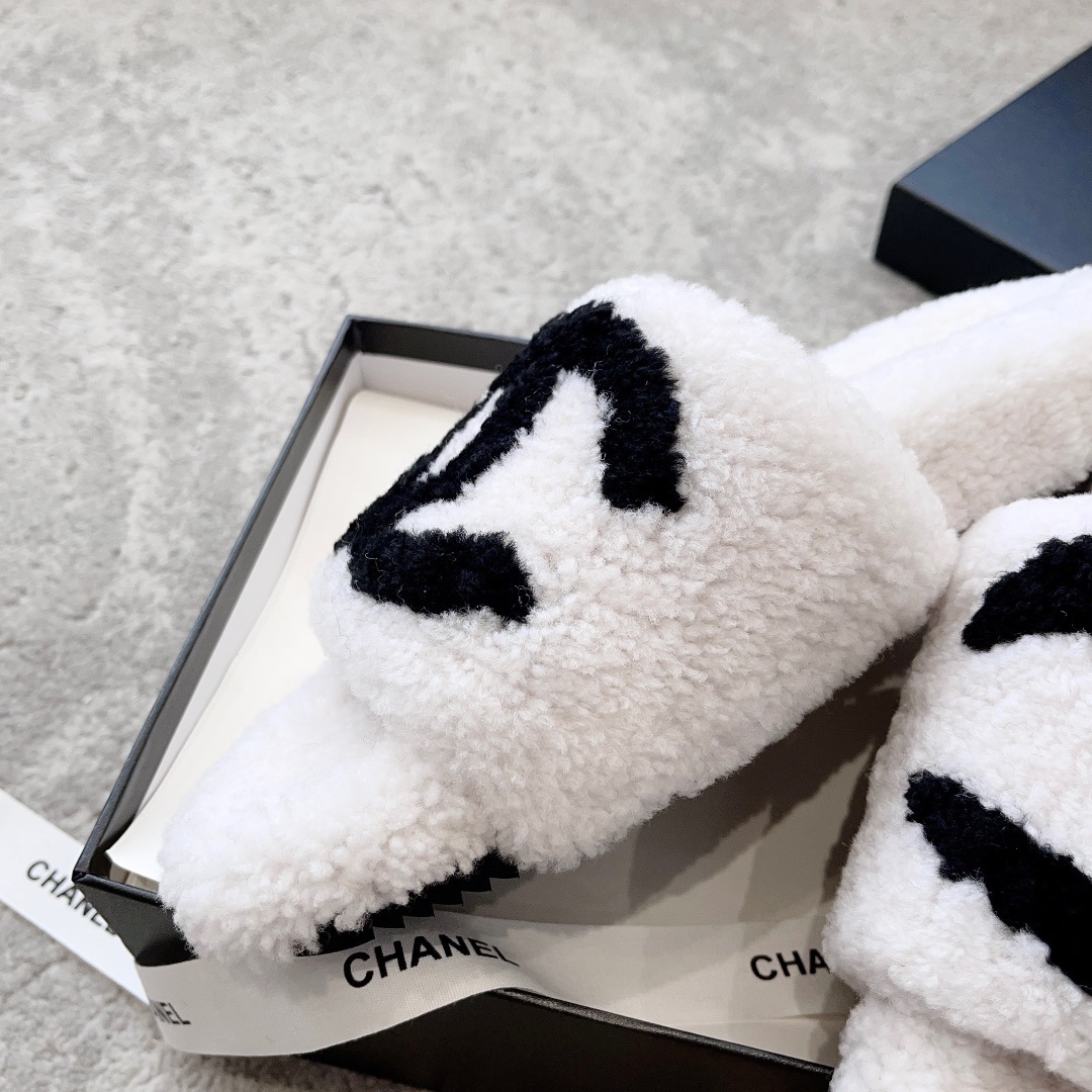 Pair of white plush shearling slides with black interlocking CC logo sitting on a designer box - Hình 7