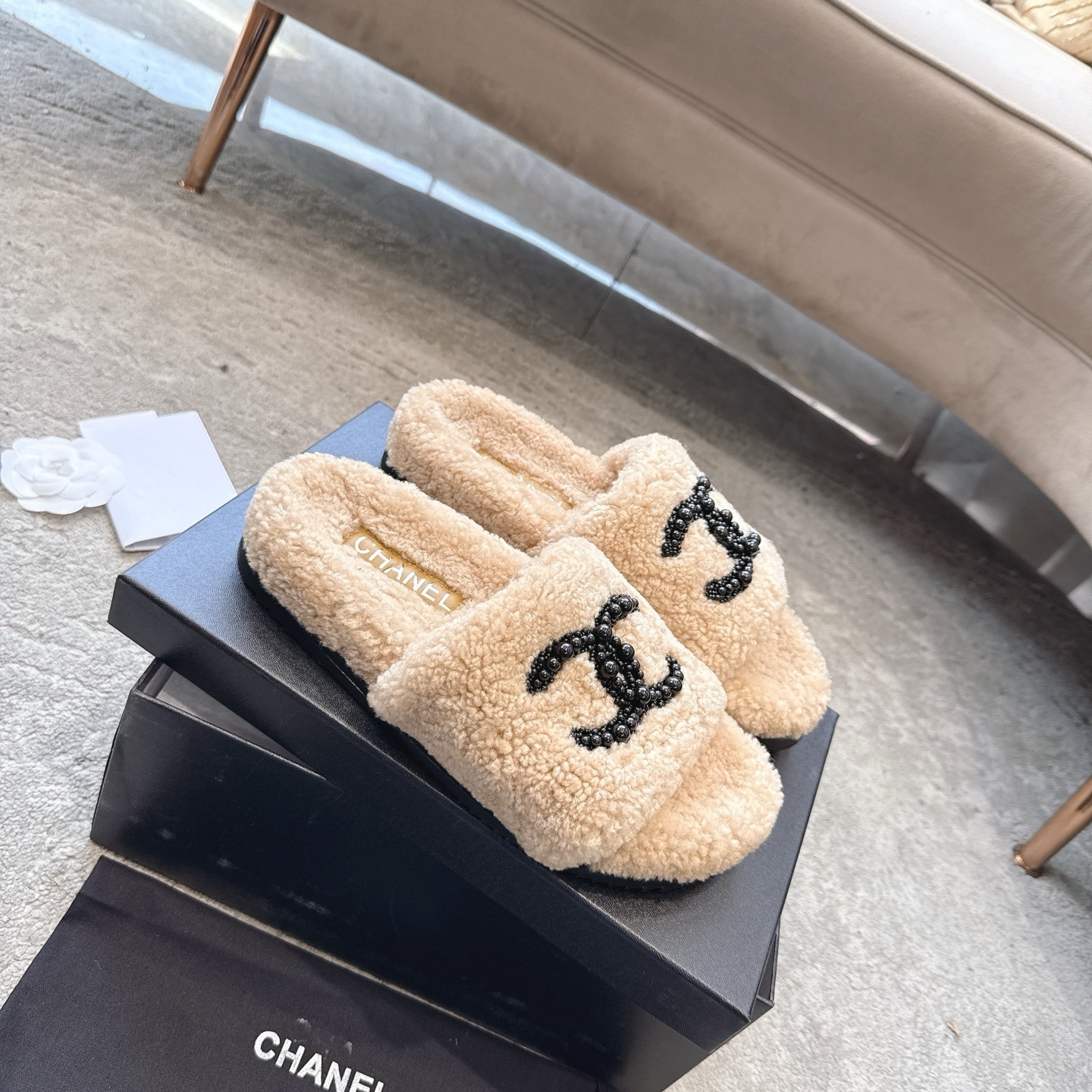 Pair of Chanel beige fuzzy shearling slide sandals with black beaded interlocking CC logo in original packaging. - Hình 6