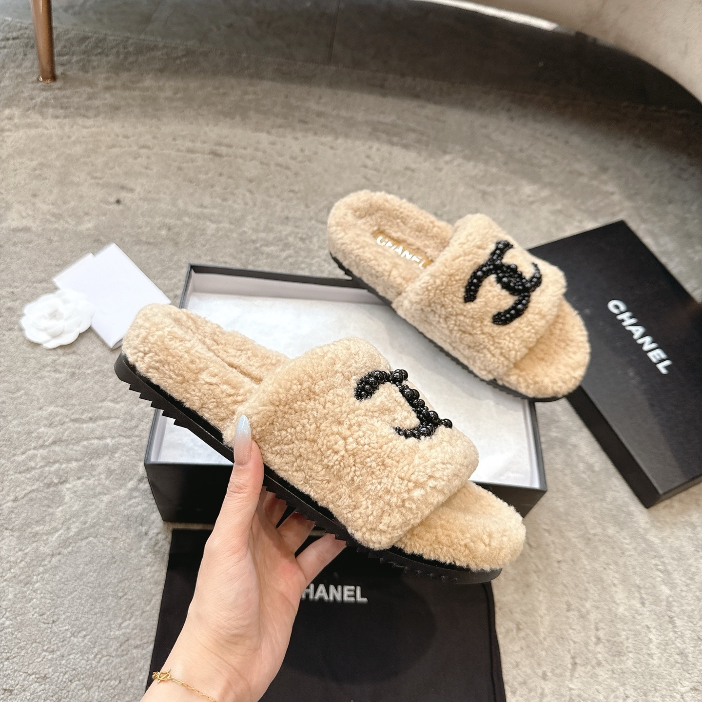 Pair of Chanel beige fuzzy shearling slide sandals with black beaded interlocking CC logo in original packaging. - Hình 3