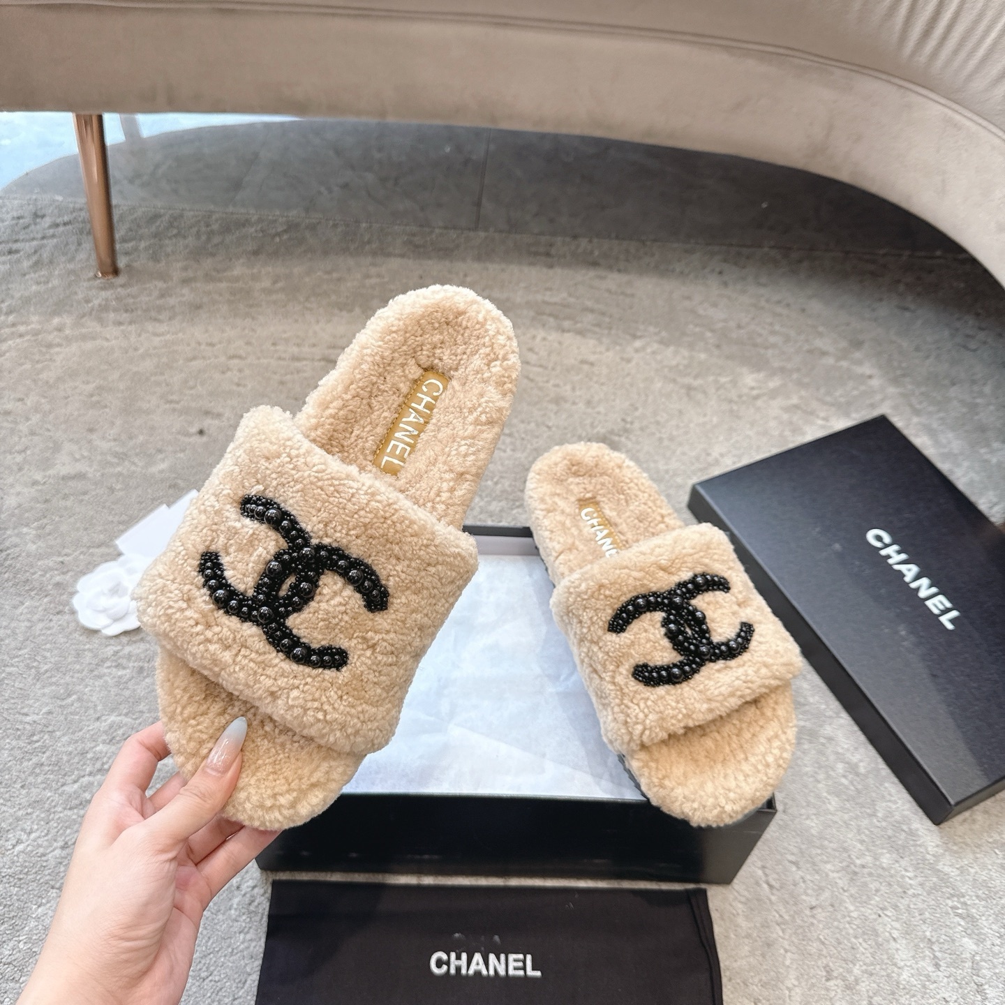 Pair of Chanel beige fuzzy shearling slide sandals with black beaded interlocking CC logo in original packaging. - Hình 2