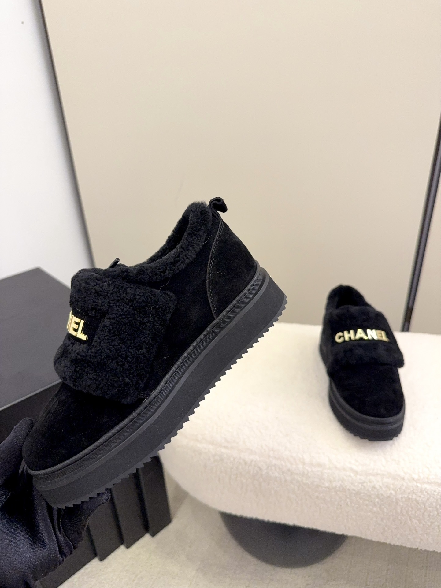 Pair of black Chanel shearling platform loafers with gold logo lettering on a white textured surface - Hình 7