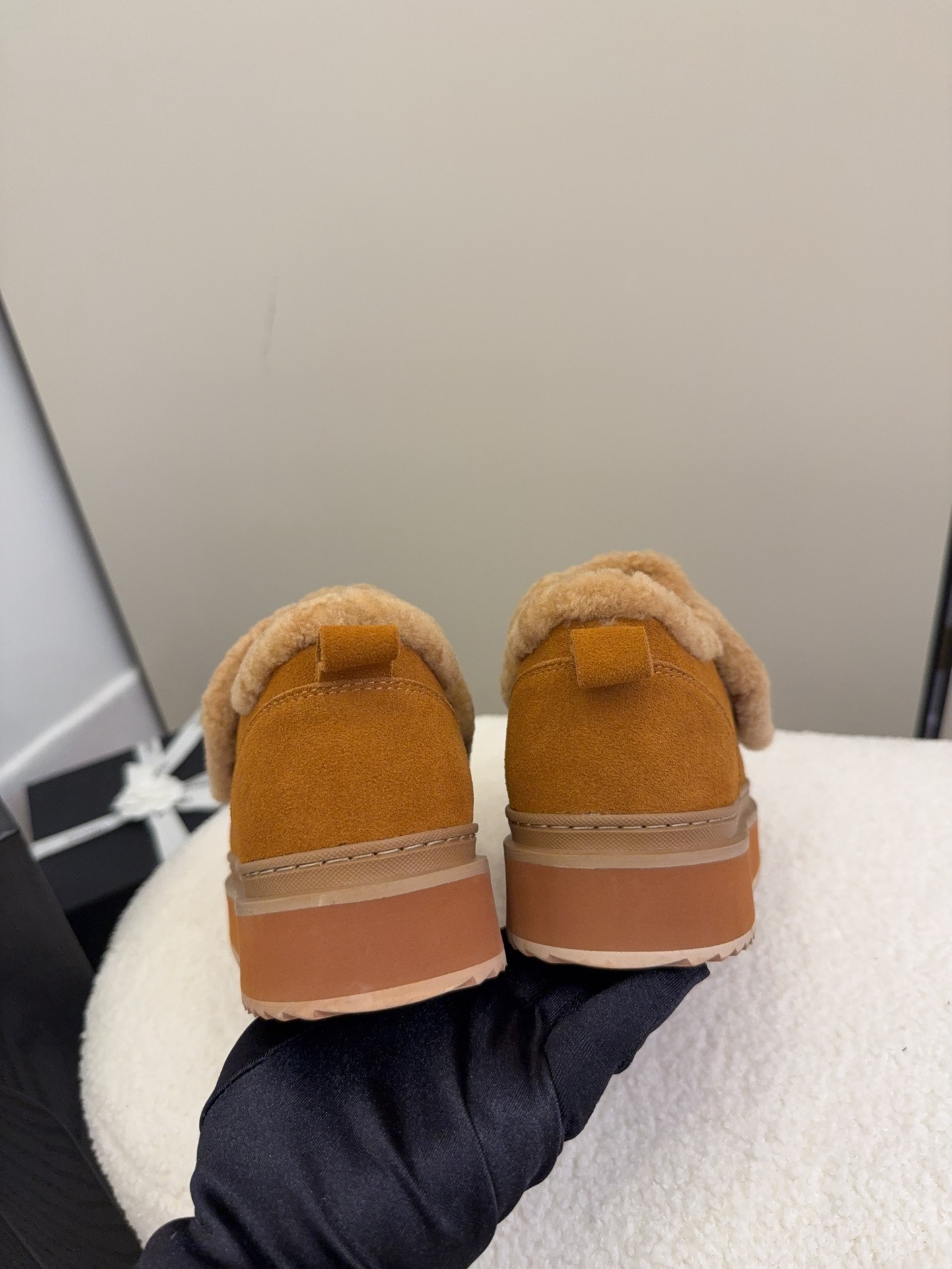 Pair of tan Chanel suede platform sneakers with shearling lining and gold logo strap on a white textured surface. - Hình 8