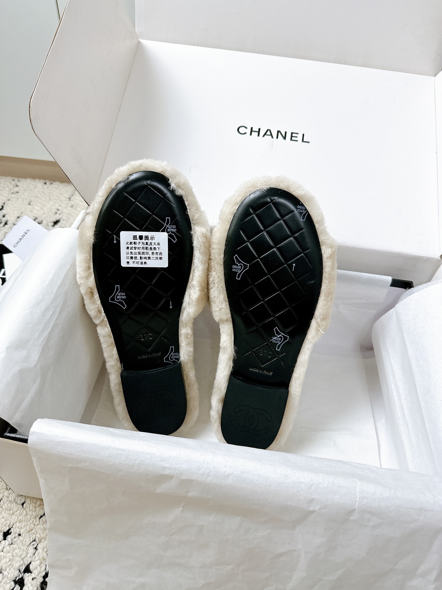 A pair of luxury Chanel beige shearling quilted slides with gold CC logo inside a white Chanel box - Hình 9