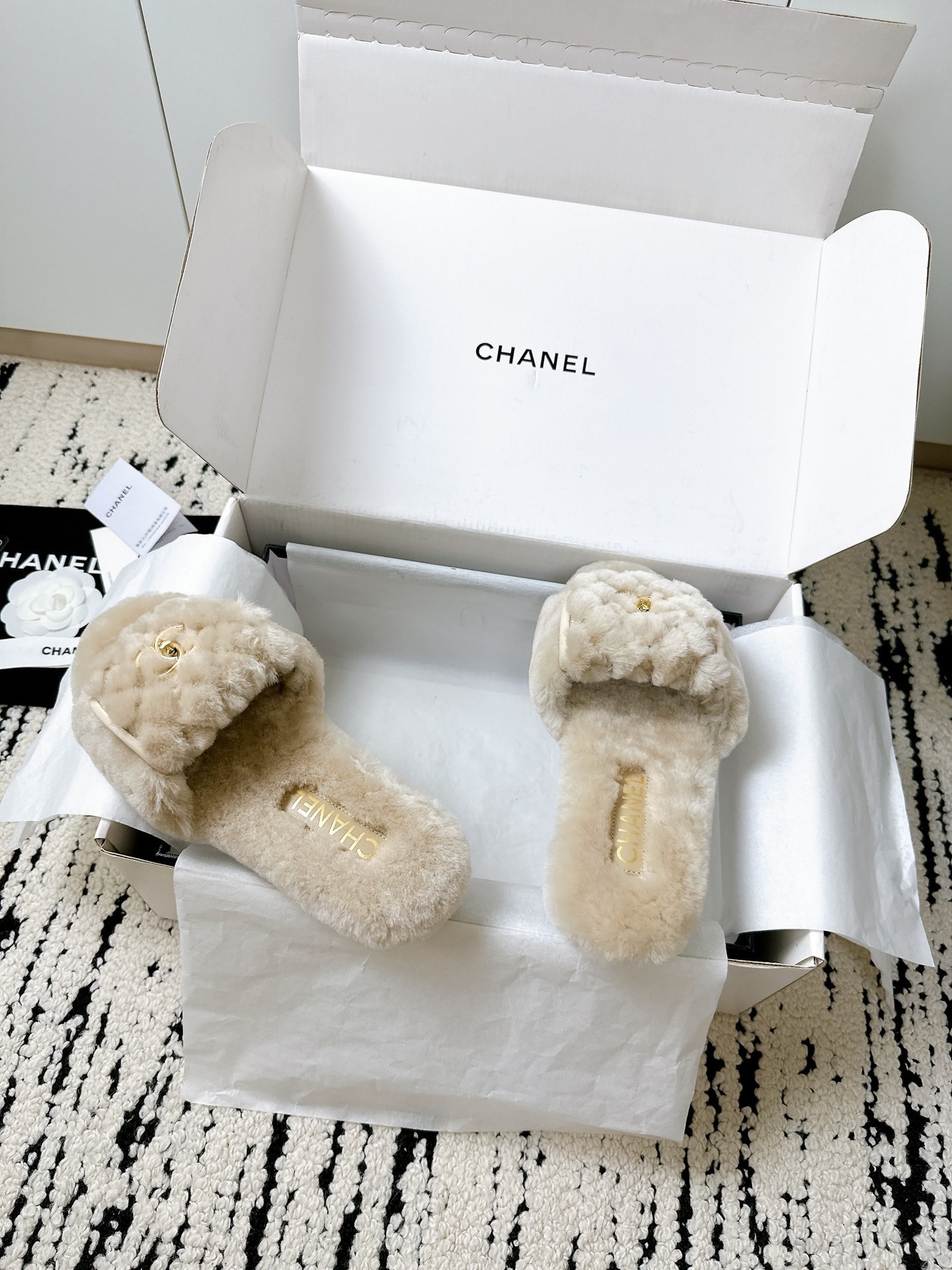 A pair of luxury Chanel beige shearling quilted slides with gold CC logo inside a white Chanel box - Hình 6