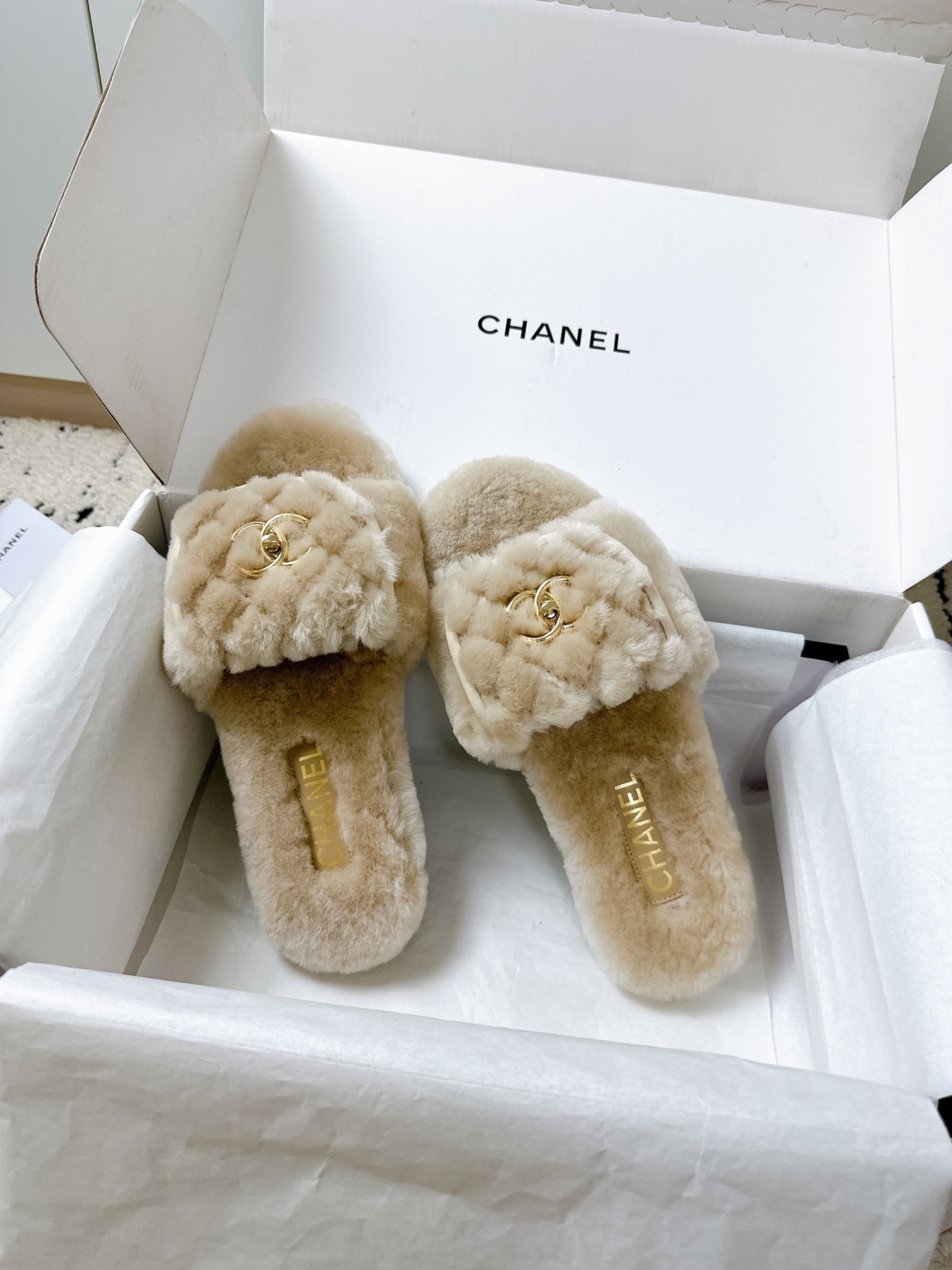 A pair of luxury Chanel beige shearling quilted slides with gold CC logo inside a white Chanel box - Hình 4