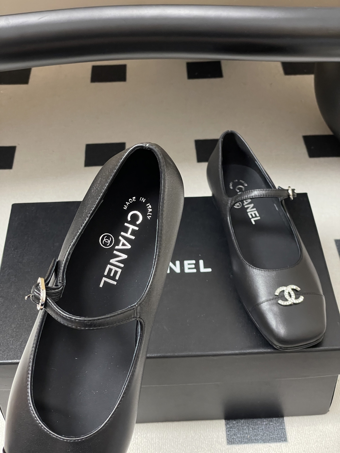 A pair of black leather Chanel Mary Jane flats featuring crystal-embellished CC logos on the toes and crystal buckles on the straps. - Hình 7