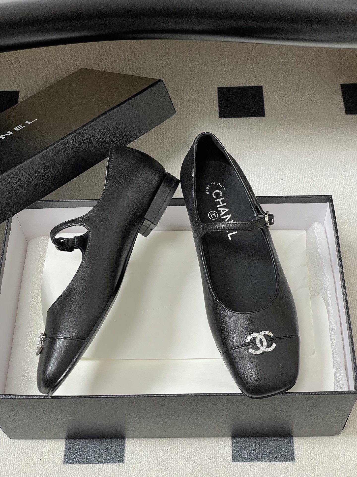 A pair of black leather Chanel Mary Jane flats featuring crystal-embellished CC logos on the toes and crystal buckles on the straps. - Hình 6