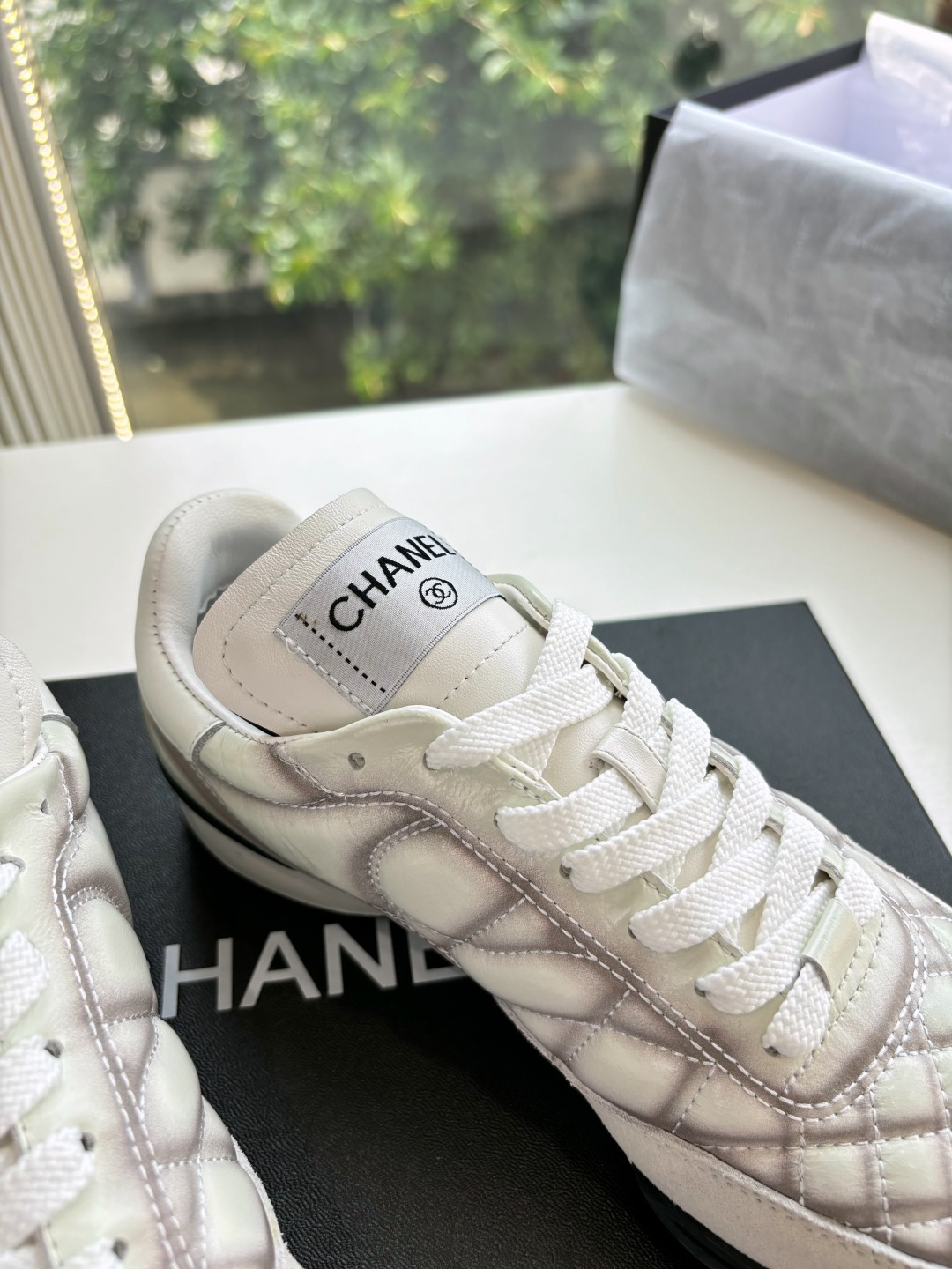 A pair of premium Chanel white quilted sneakers with grey shadow detailing and interlocking CC logo, displayed in their original black box. - Hình 8