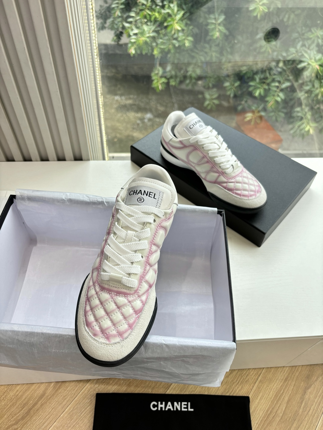 A pair of luxury Chanel sneakers featuring white and pink quilted leather, suede accents, and the interlocking CC logo. - Hình 2