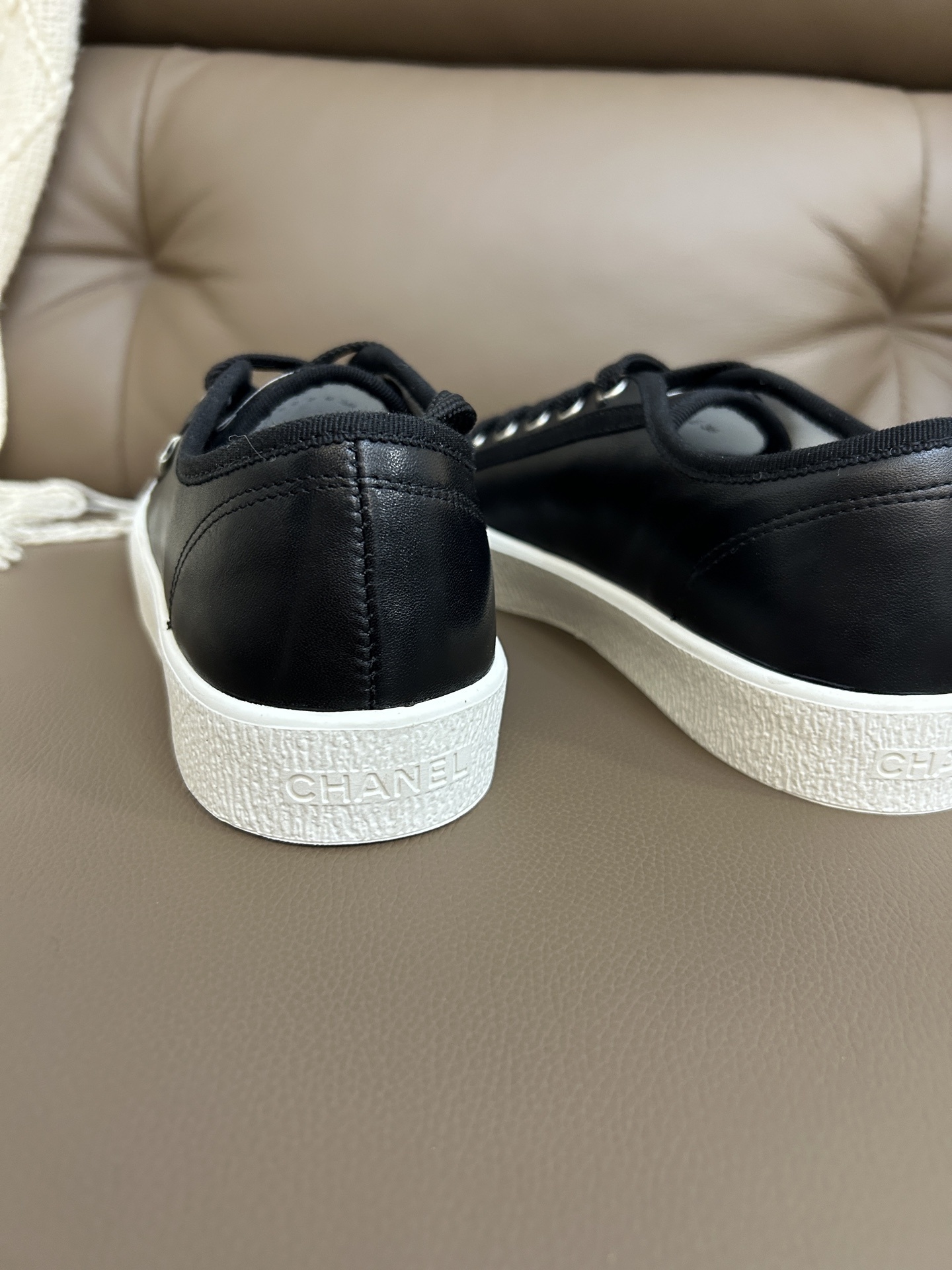 Luxury Chanel black leather sneakers with white rubber soles and embossed CC logo on the toe cap. - Hình 9