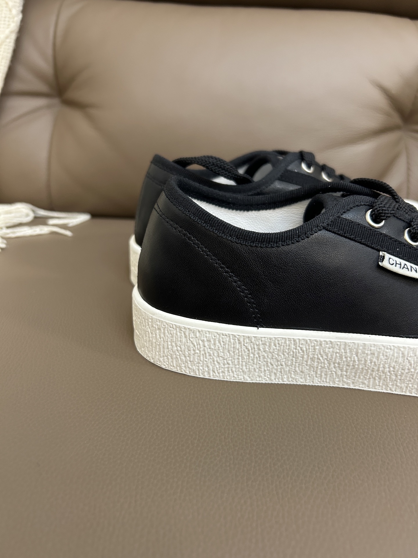 Luxury Chanel black leather sneakers with white rubber soles and embossed CC logo on the toe cap. - Hình 8