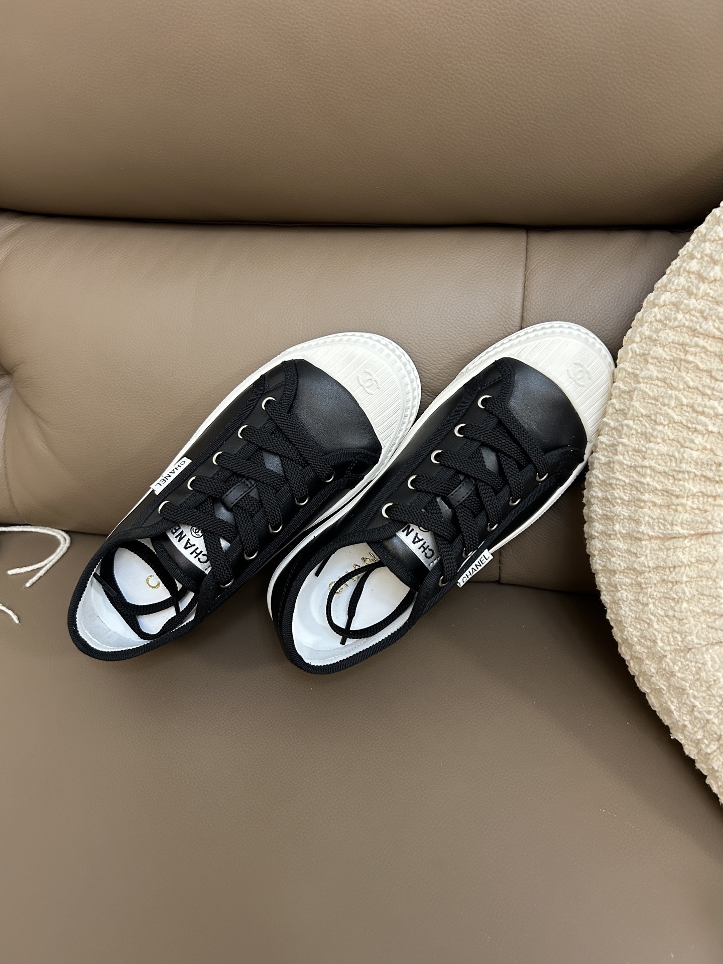 Luxury Chanel black leather sneakers with white rubber soles and embossed CC logo on the toe cap. - Hình 4