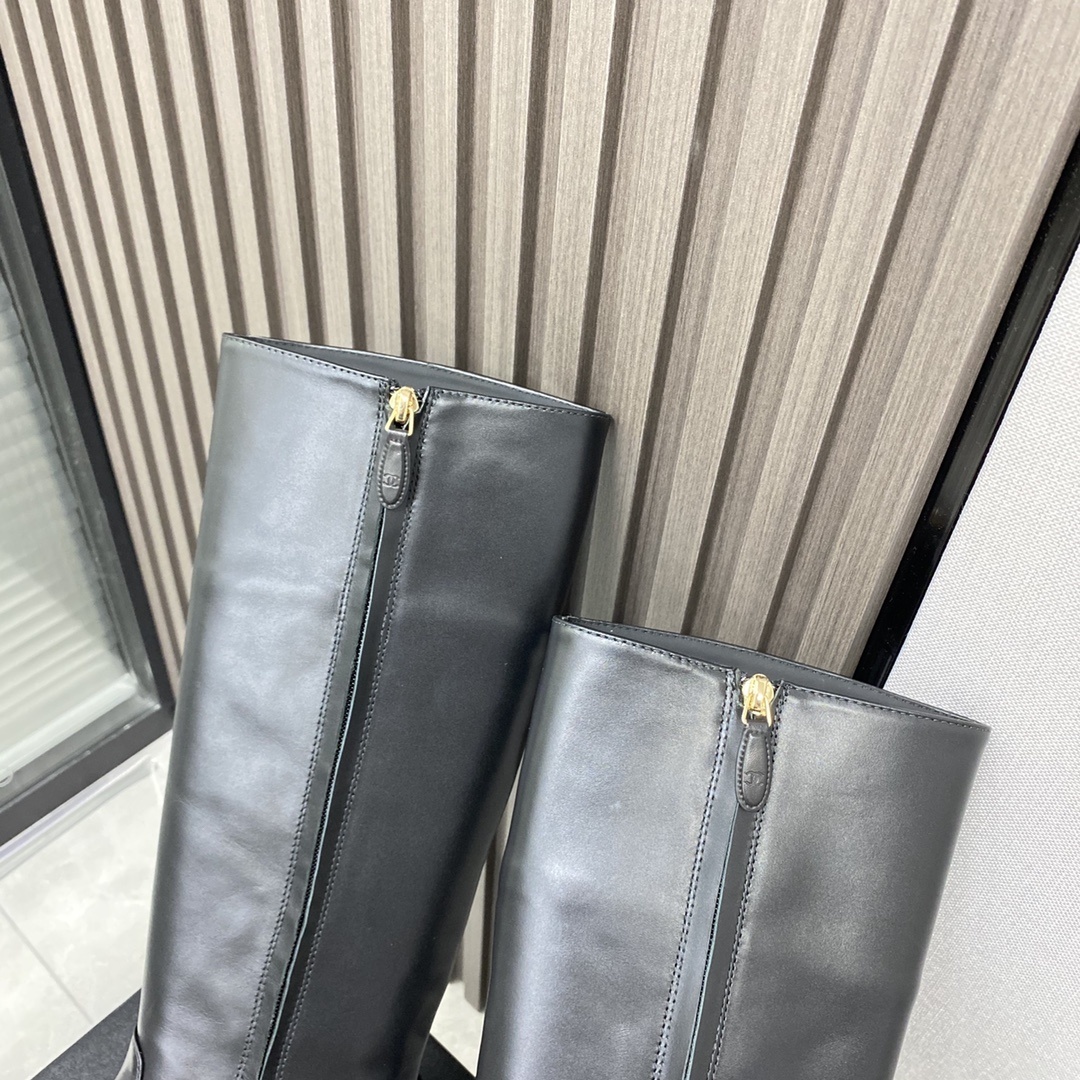 Pair of black leather knee-high boots with gold chain detail on a black designer box - Hình 9