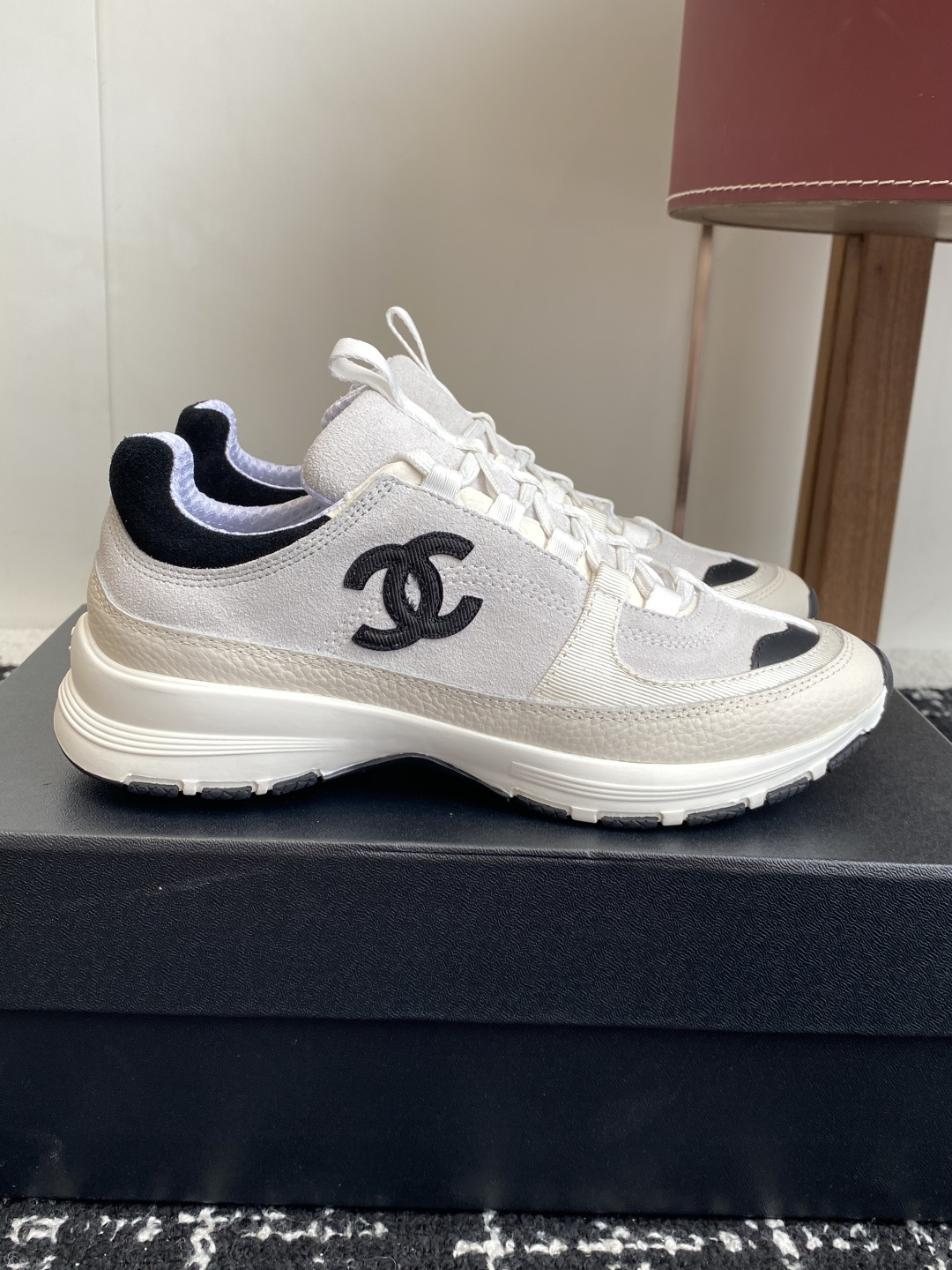 Pair of Chanel white and black suede mesh sneakers with CC logo on a black box - Hình 2