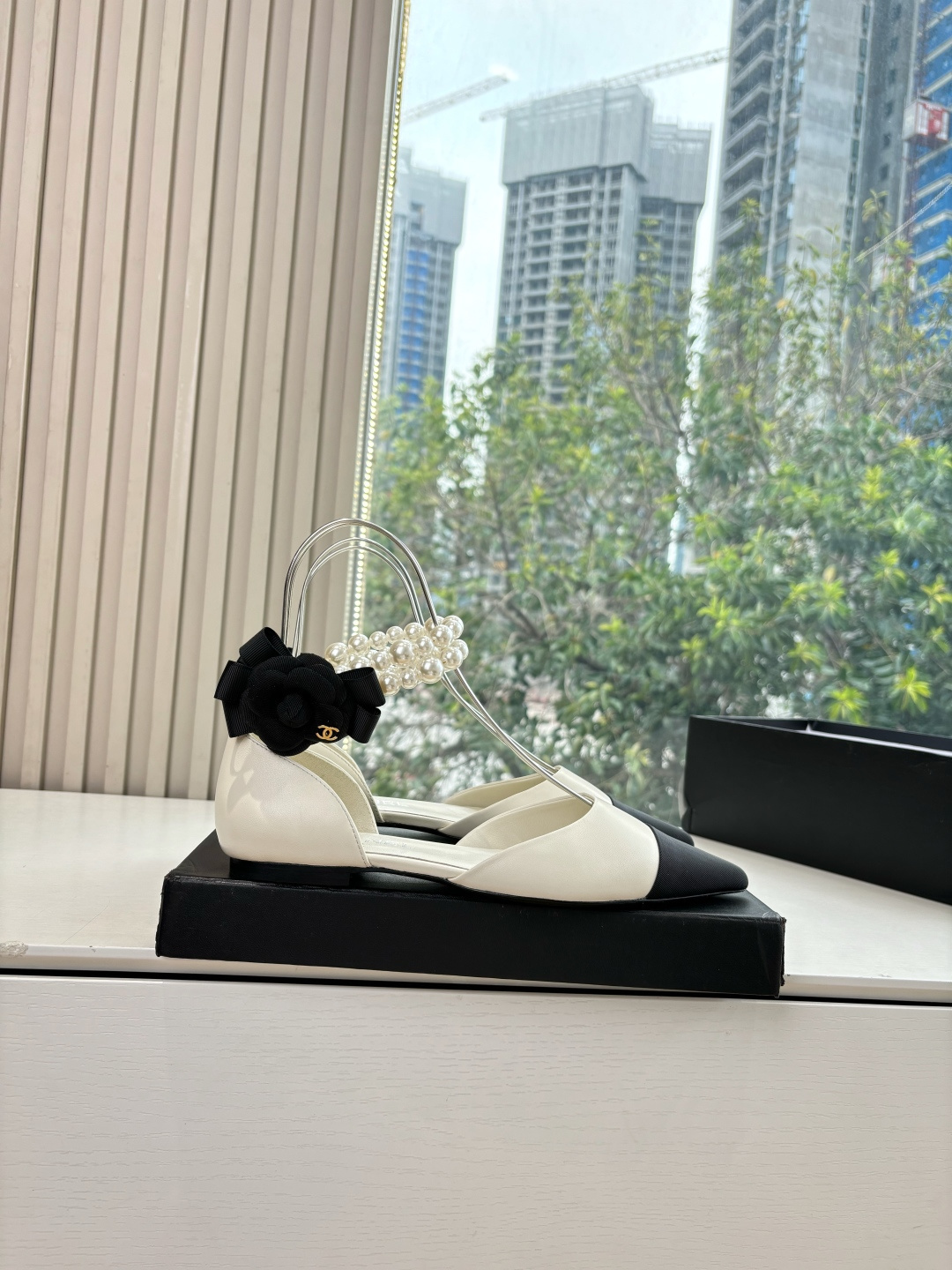 Pair of Chanel ivory leather pointed-toe flats with black cap-toe, pearl ankle straps, and black camellia flower detail on the heel. - Hình 7