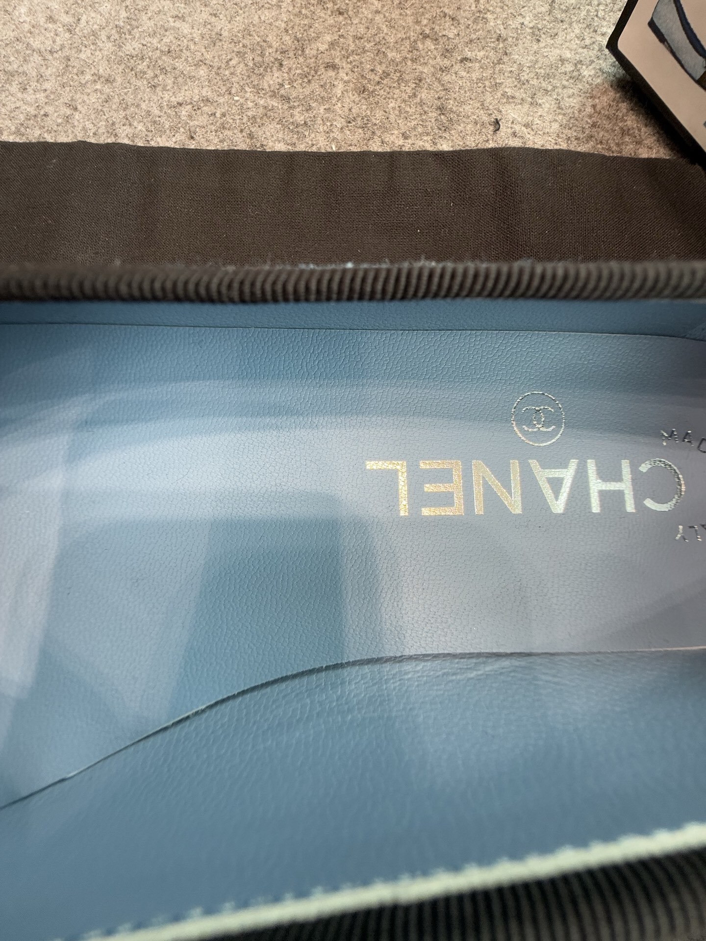 Pair of Chanel light blue quilted denim ballerina flats with black toe caps and bows inside a white luxury box. - Hình 9