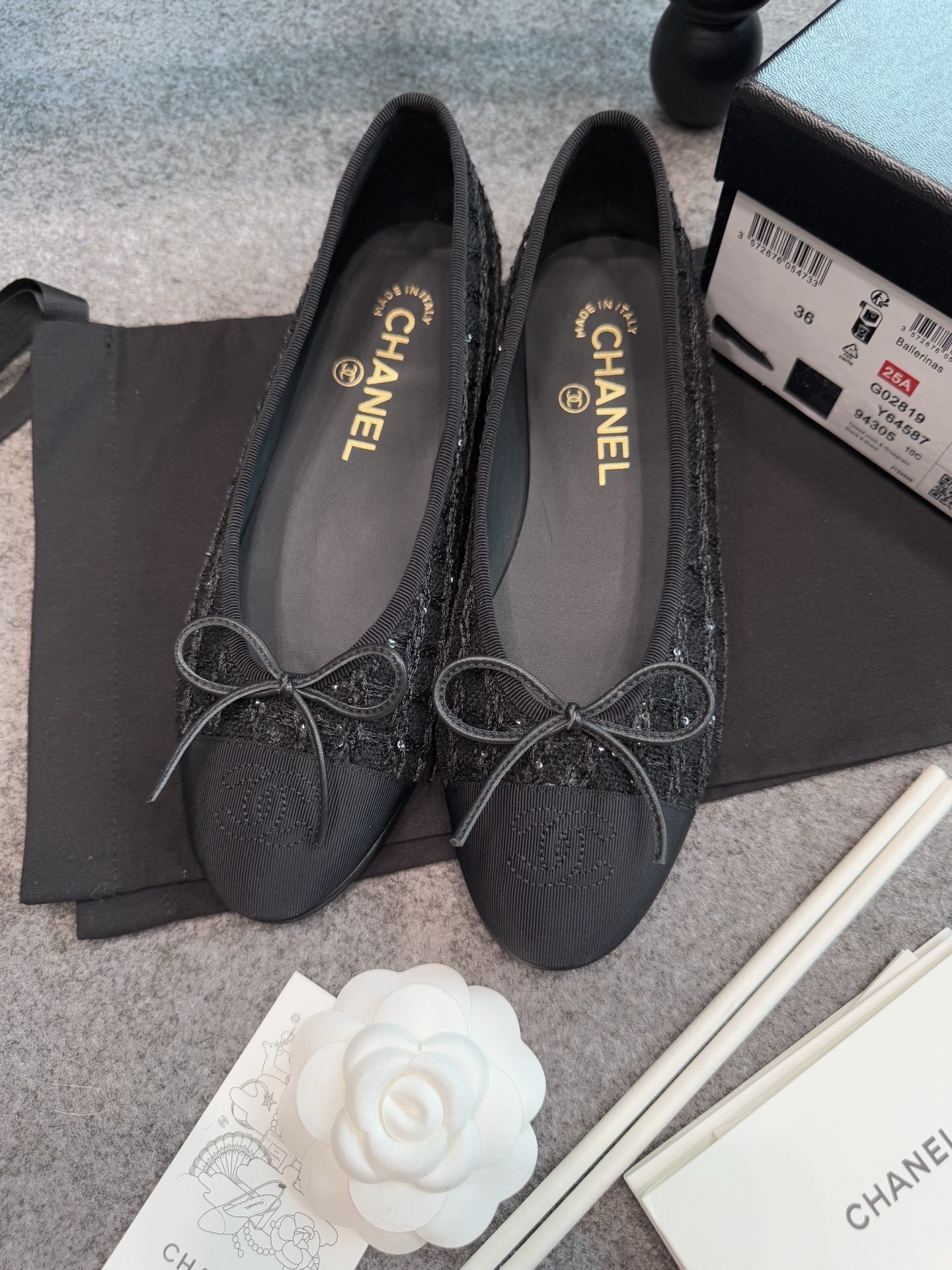 Top view of Chanel black tweed ballet flats with sequins and CC logo toe cap on a luxury display - Hình 8