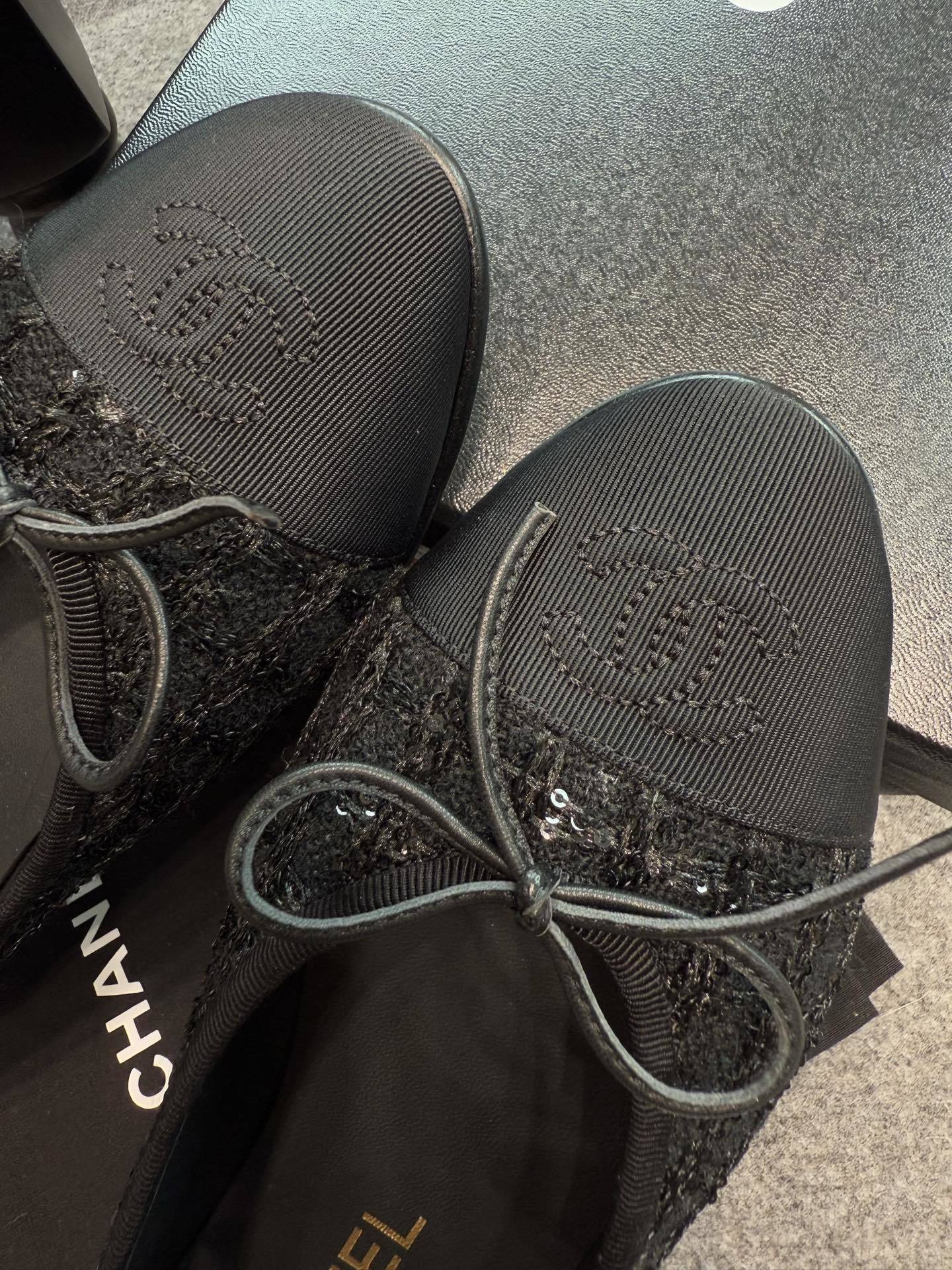 Top view of Chanel black tweed ballet flats with sequins and CC logo toe cap on a luxury display - Hình 6
