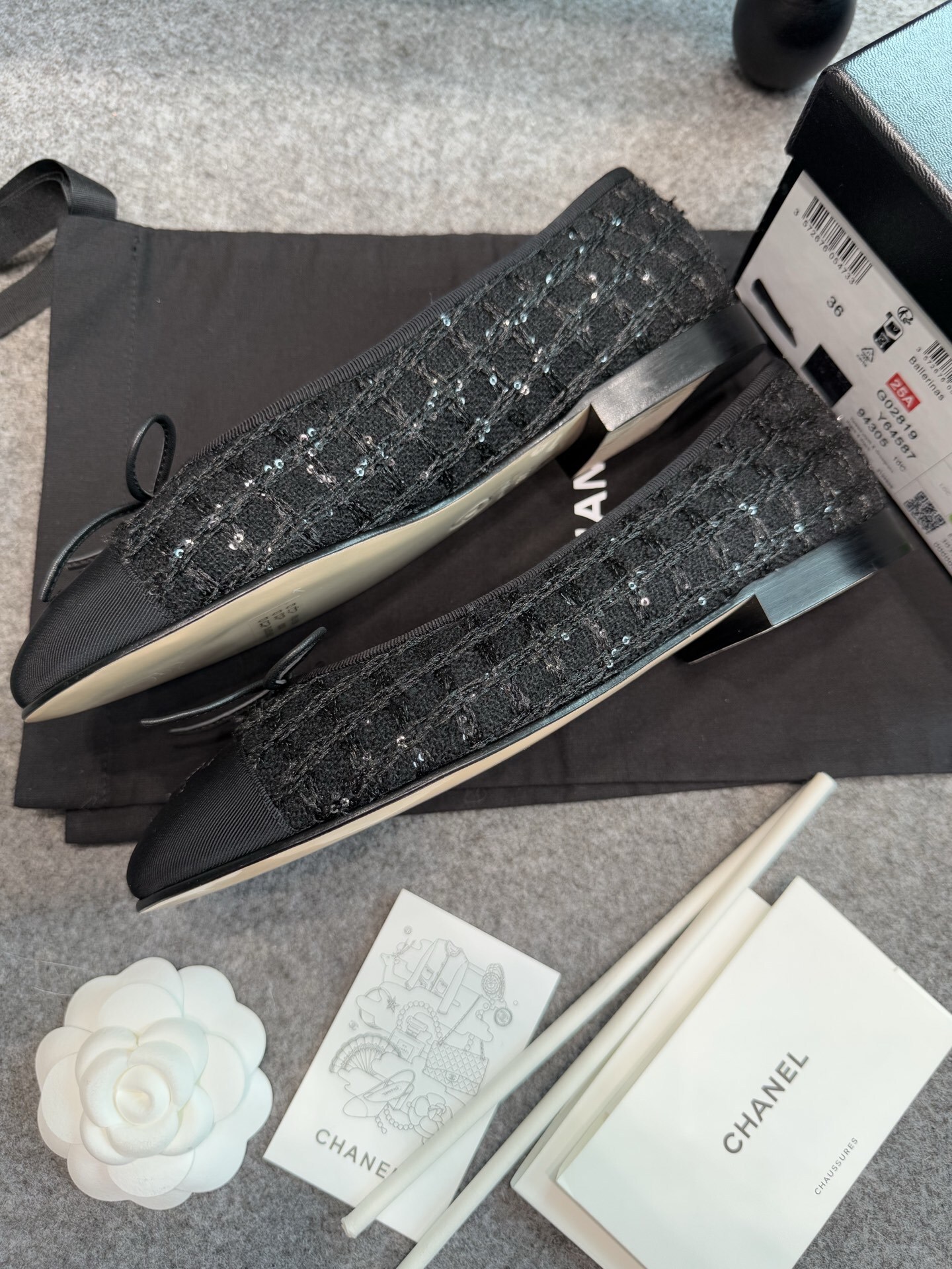 Top view of Chanel black tweed ballet flats with sequins and CC logo toe cap on a luxury display - Hình 4