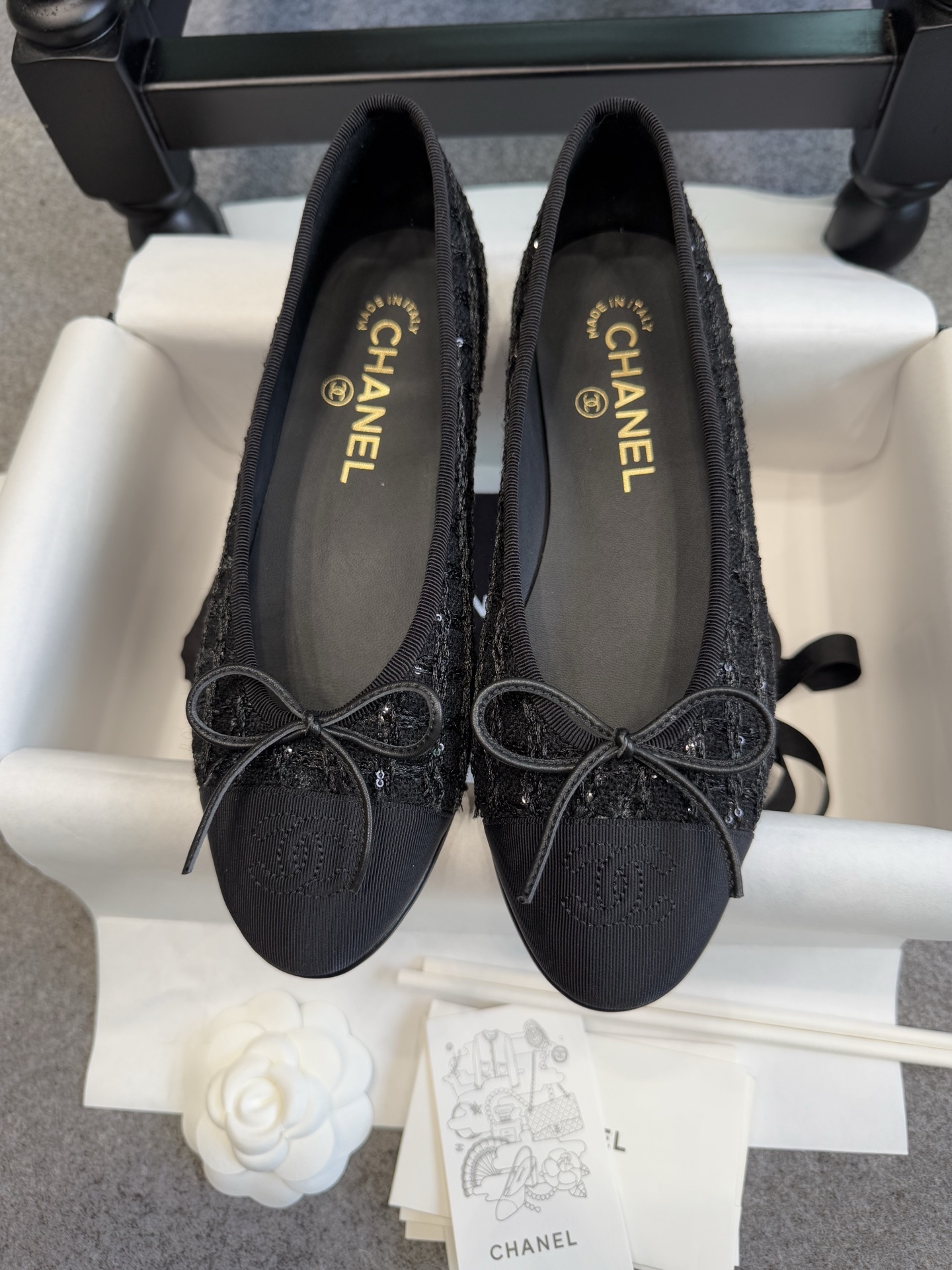 Top view of Chanel black tweed ballet flats with sequins and CC logo toe cap on a luxury display - Hình 2