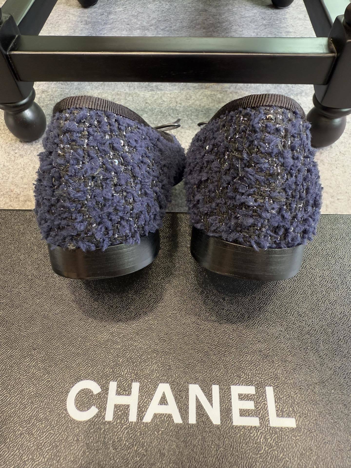 A pair of Chanel dark blue tweed ballet flats with black leather toe caps and CC logo, shown with original box and packaging. - Hình 5