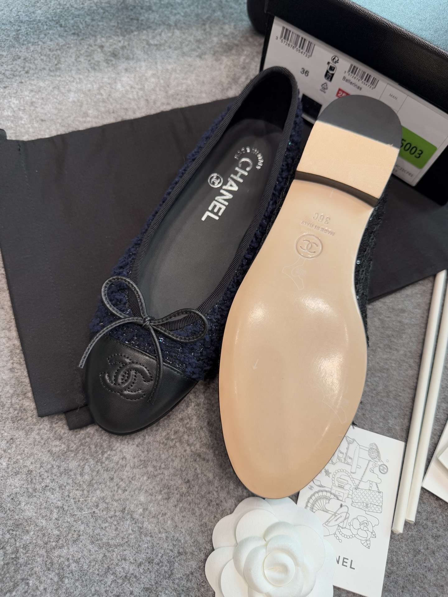 A pair of Chanel dark blue tweed ballet flats with black leather toe caps and CC logo, shown with original box and packaging. - Hình 4