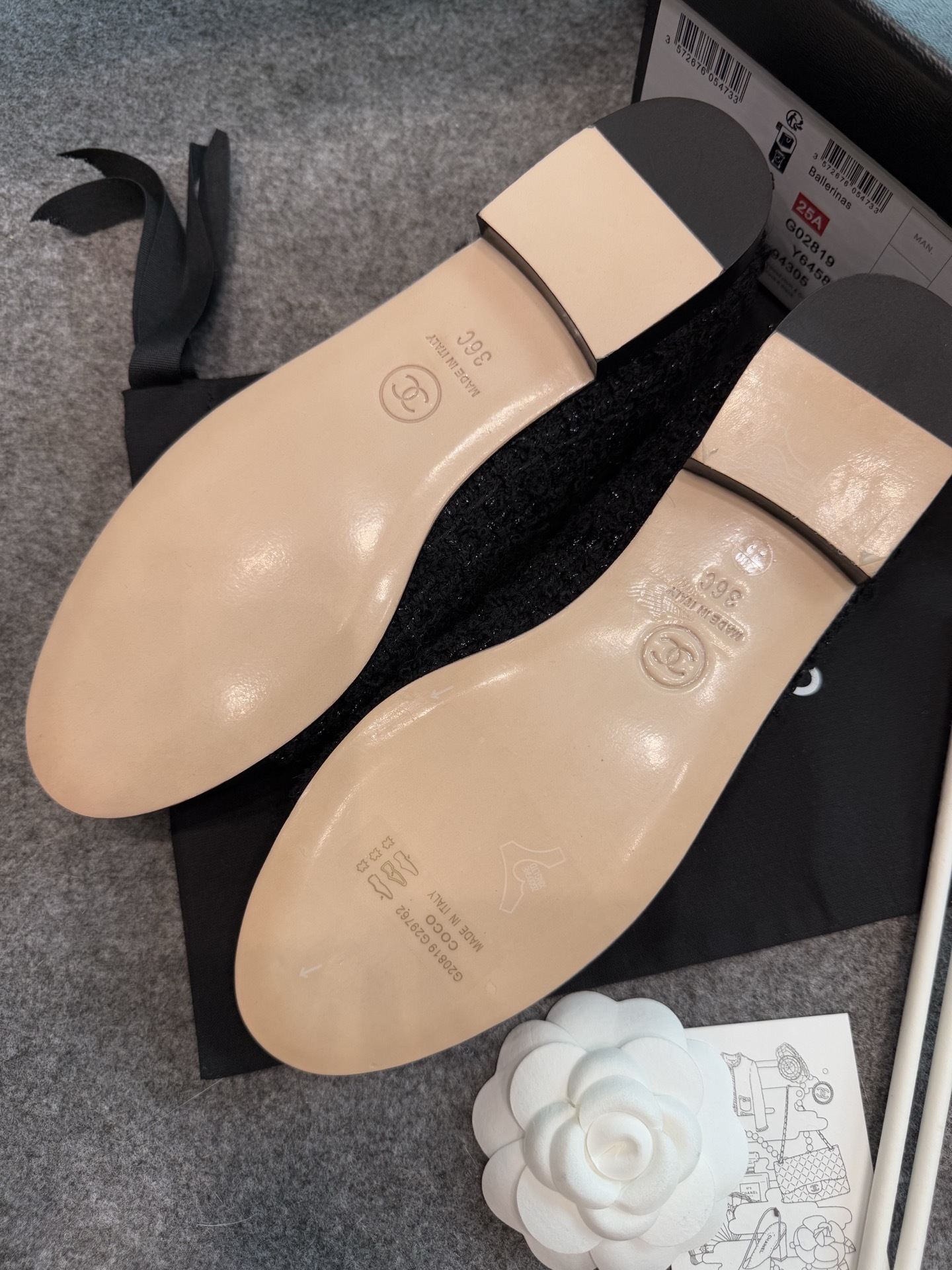 A pair of black Chanel tweed ballerina flats with leather CC logo toe caps and bow details inside a luxury box. - Hình 8