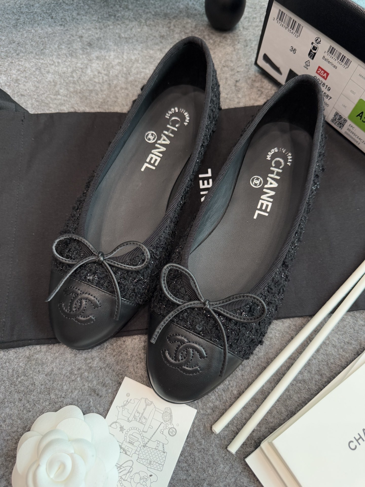 A pair of black Chanel tweed ballerina flats with leather CC logo toe caps and bow details inside a luxury box. - Hình 4