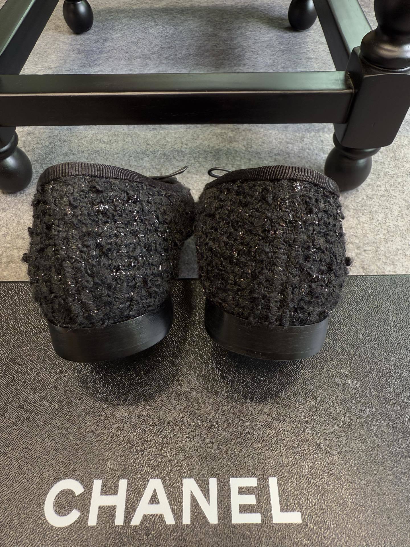 A pair of black Chanel tweed ballerina flats with leather CC logo toe caps and bow details inside a luxury box. - Hình 3