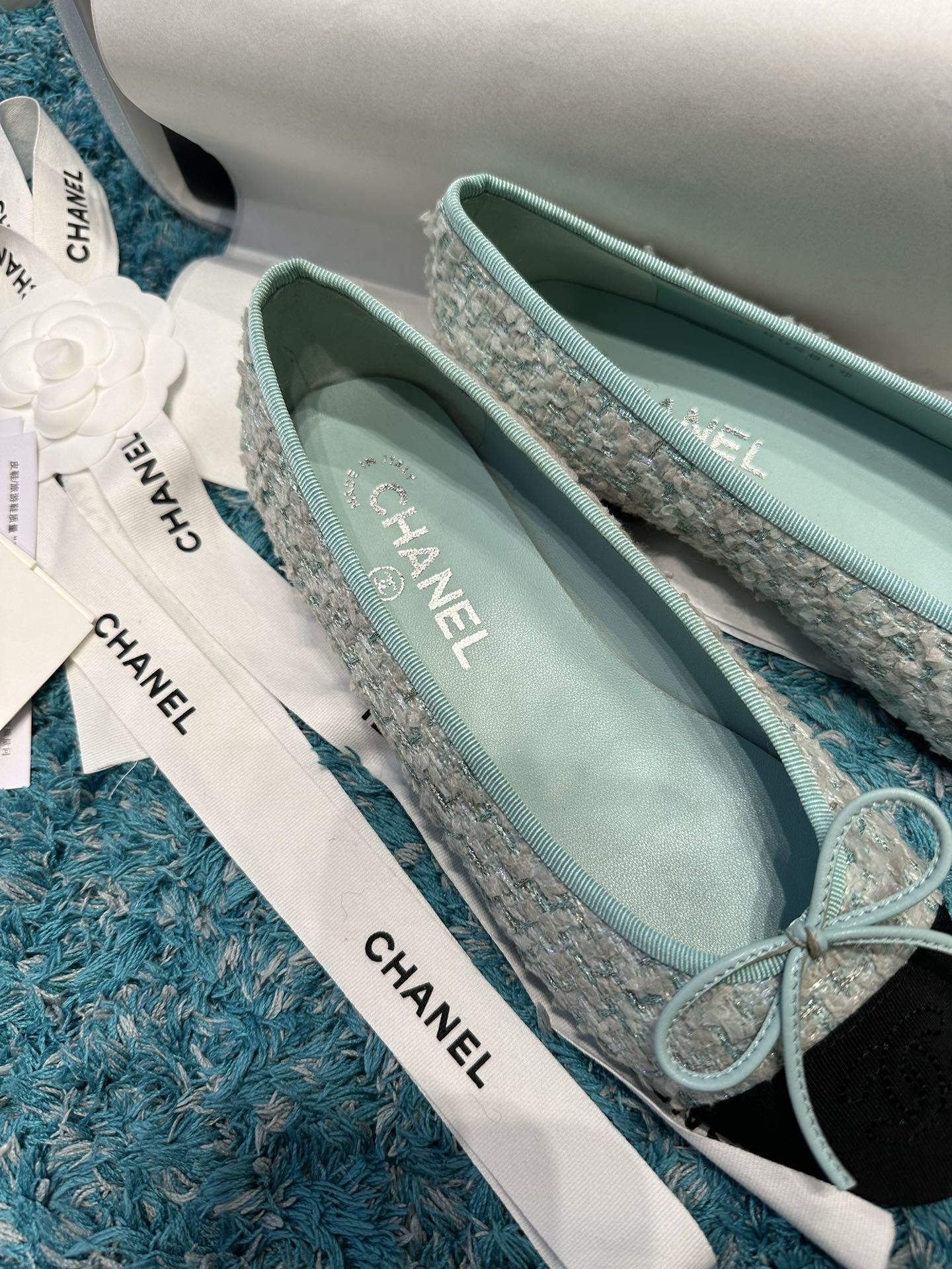Luxury Chanel ballet flats featuring light blue tweed fabric, black grosgrain cap-toes with CC logo, and a delicate bow detail. - Hình 7