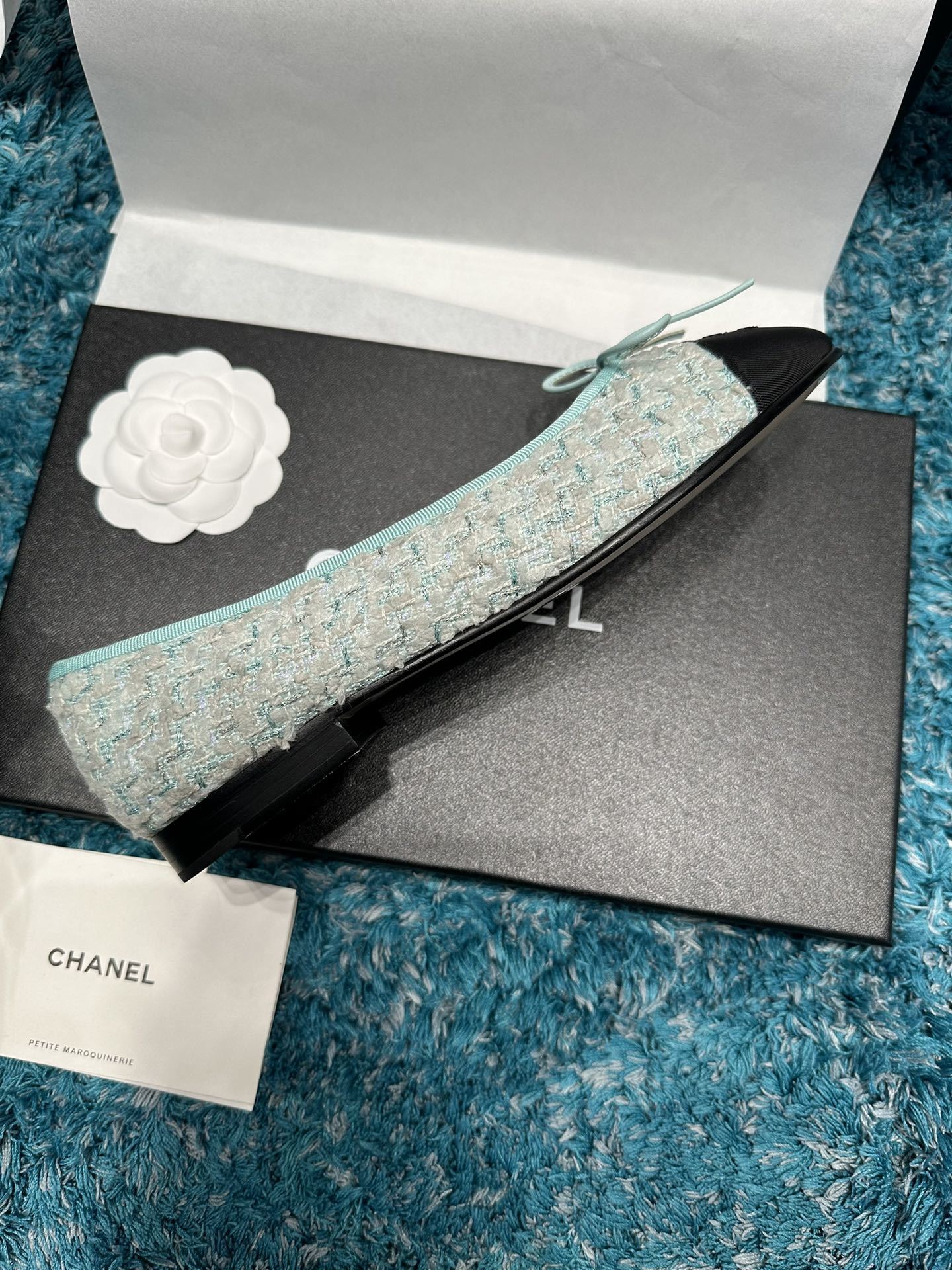 Luxury Chanel ballet flats featuring light blue tweed fabric, black grosgrain cap-toes with CC logo, and a delicate bow detail. - Hình 4